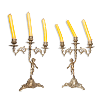 Pair of symmetrical cherub candlestick in bronze