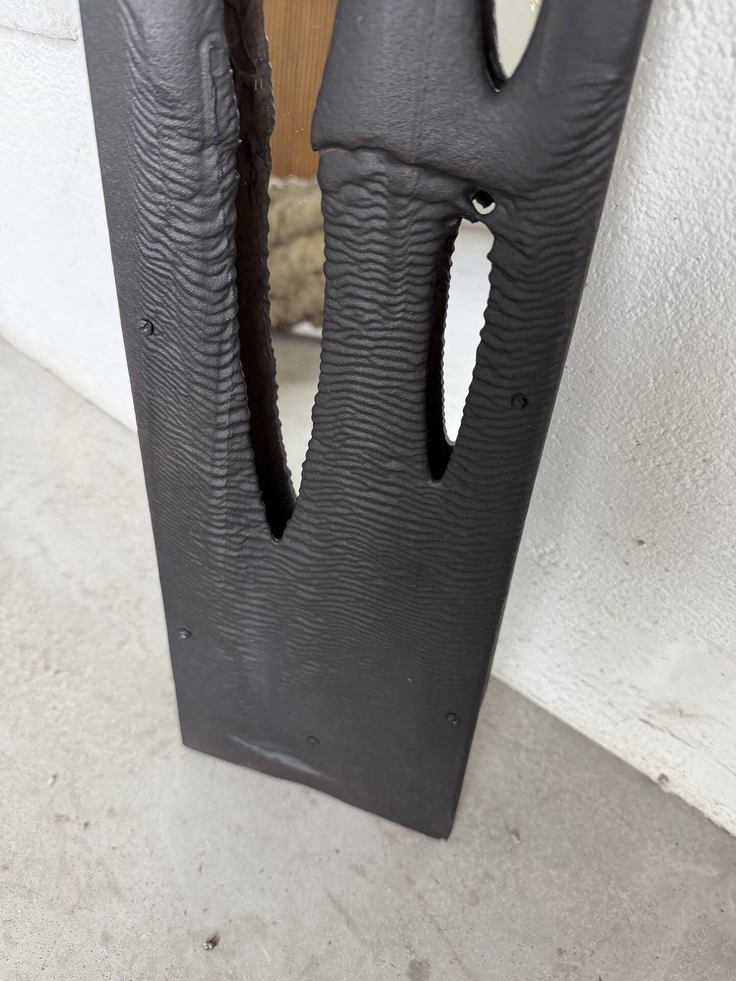 Brutalist hammered mirror, free-form, patinated metal.