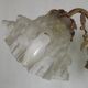 Simple wall sconce in French Art Nouveau bronze with a white glass shade featuring patterns.