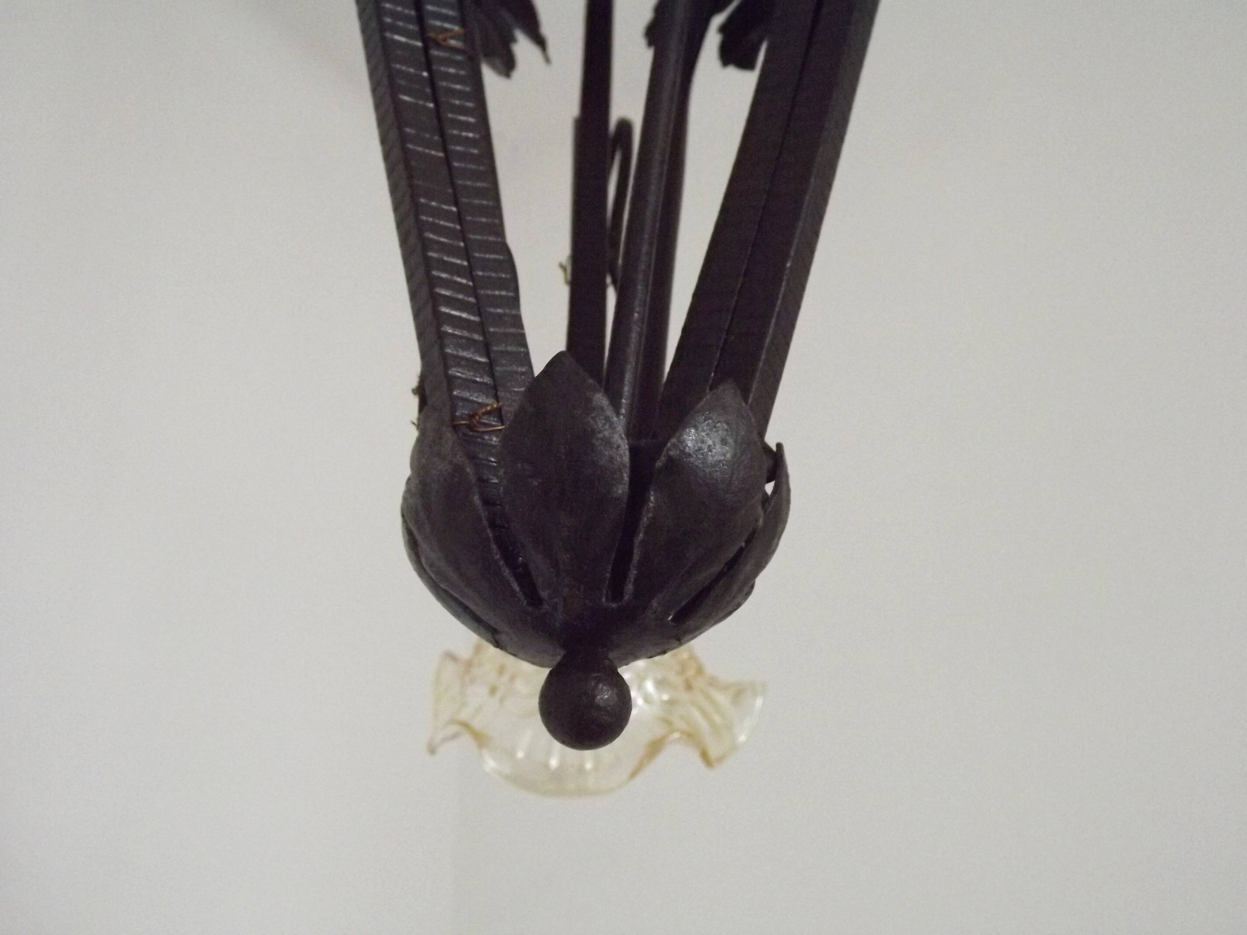 French Art Nouveau leaf detail iron three-light chandelier with amber glass shades.