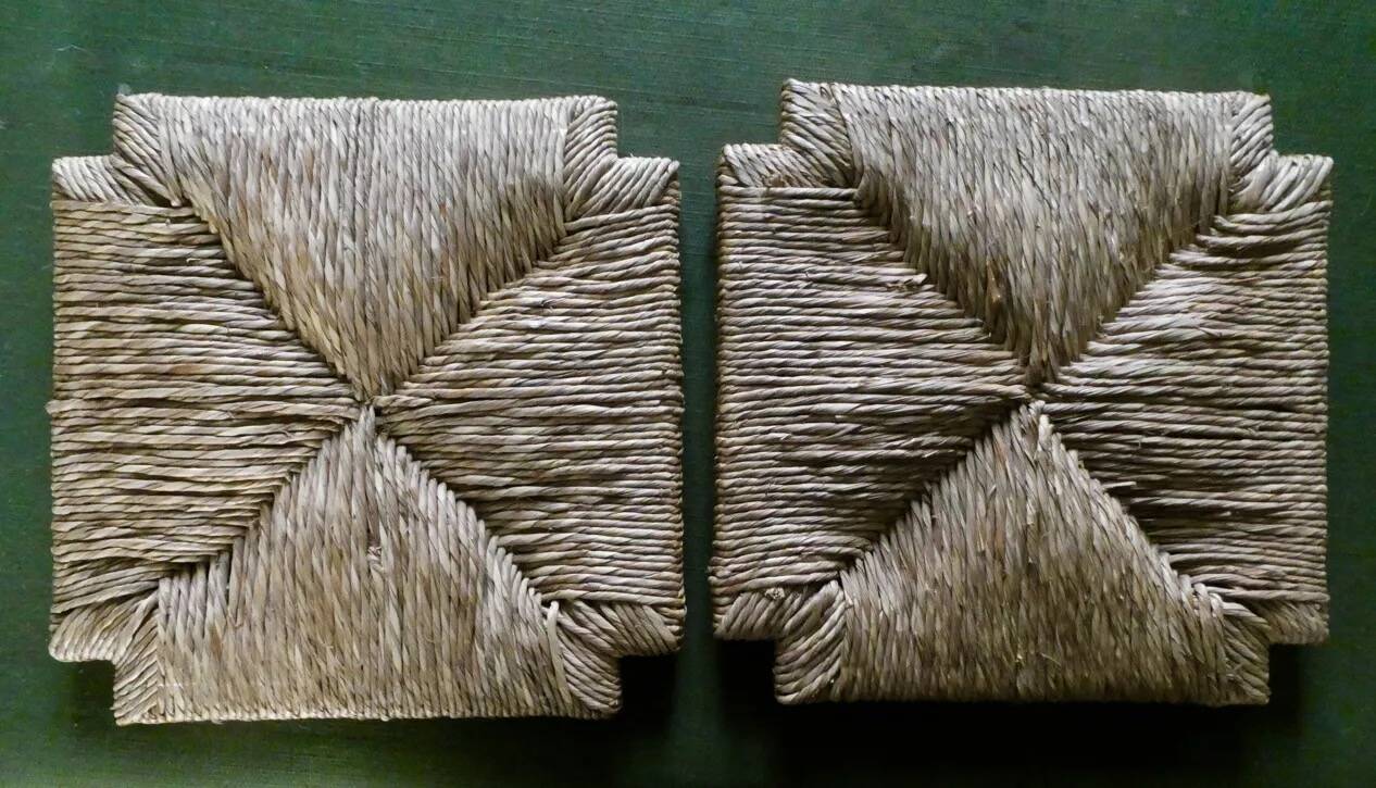 pair of bar stools, made of wood with a straw seat