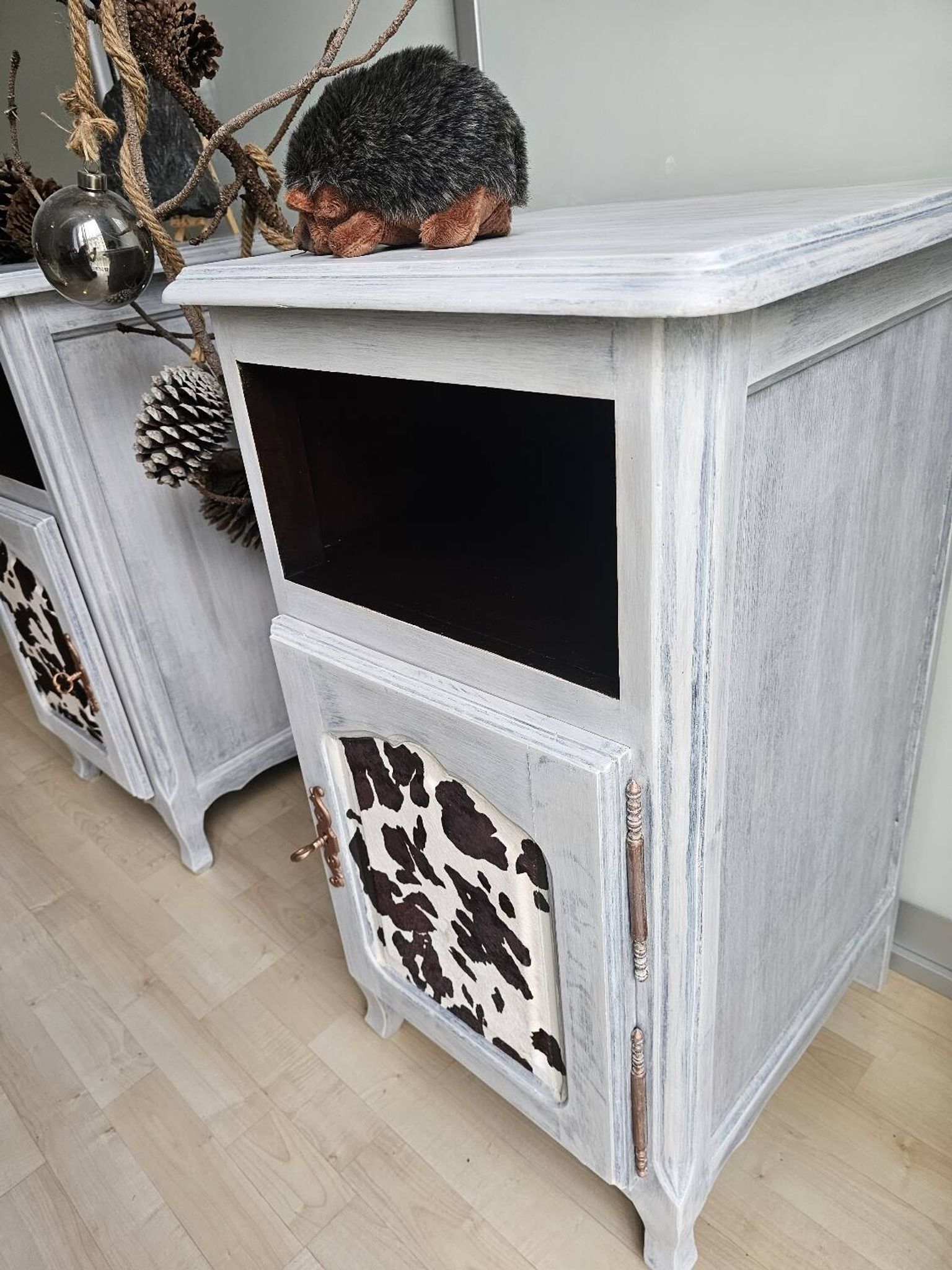 Two solid wood bedside tables with calfskin decoration.