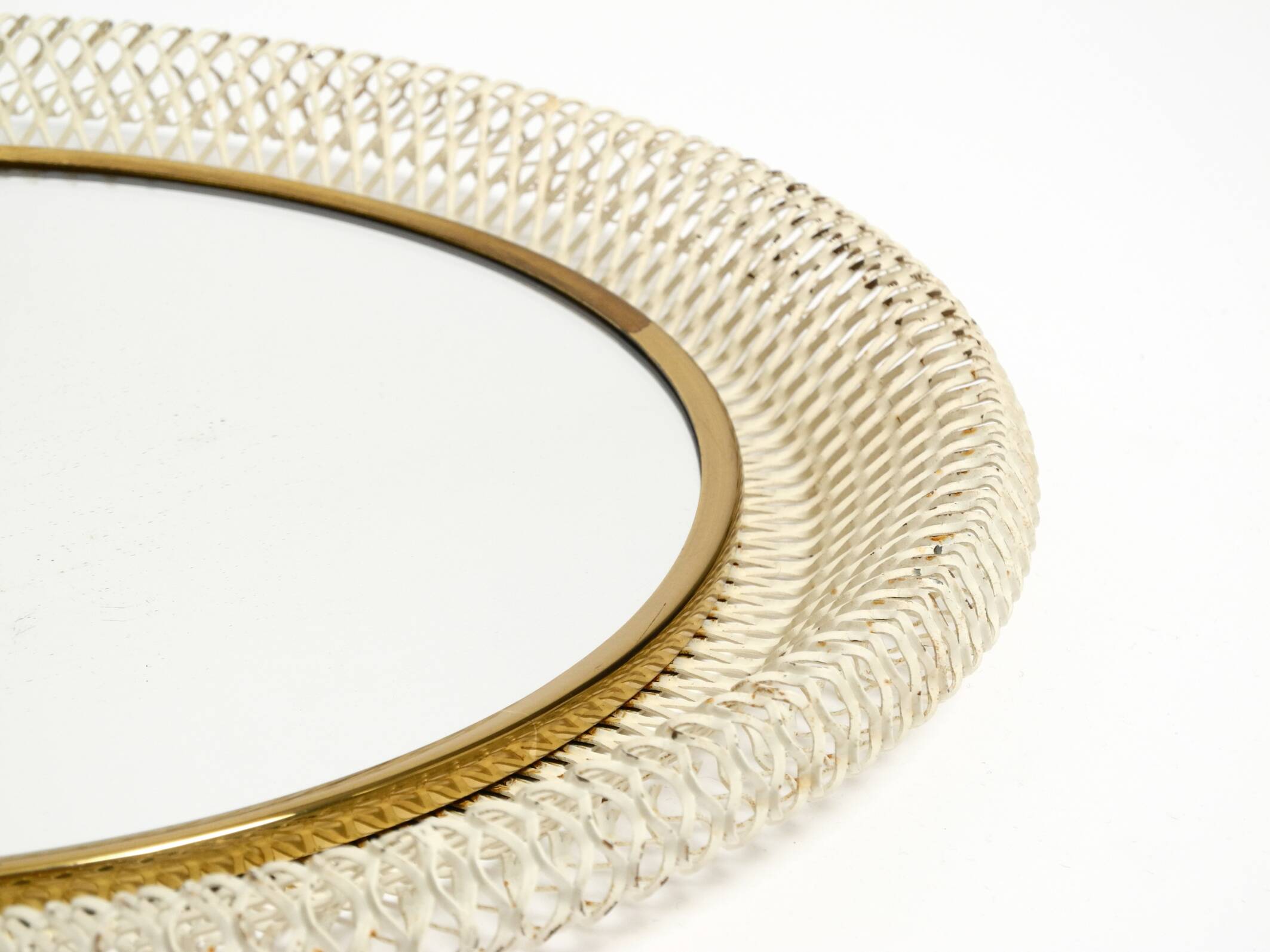 Mid Century Modern round wall mirror with a white expanded metal frame