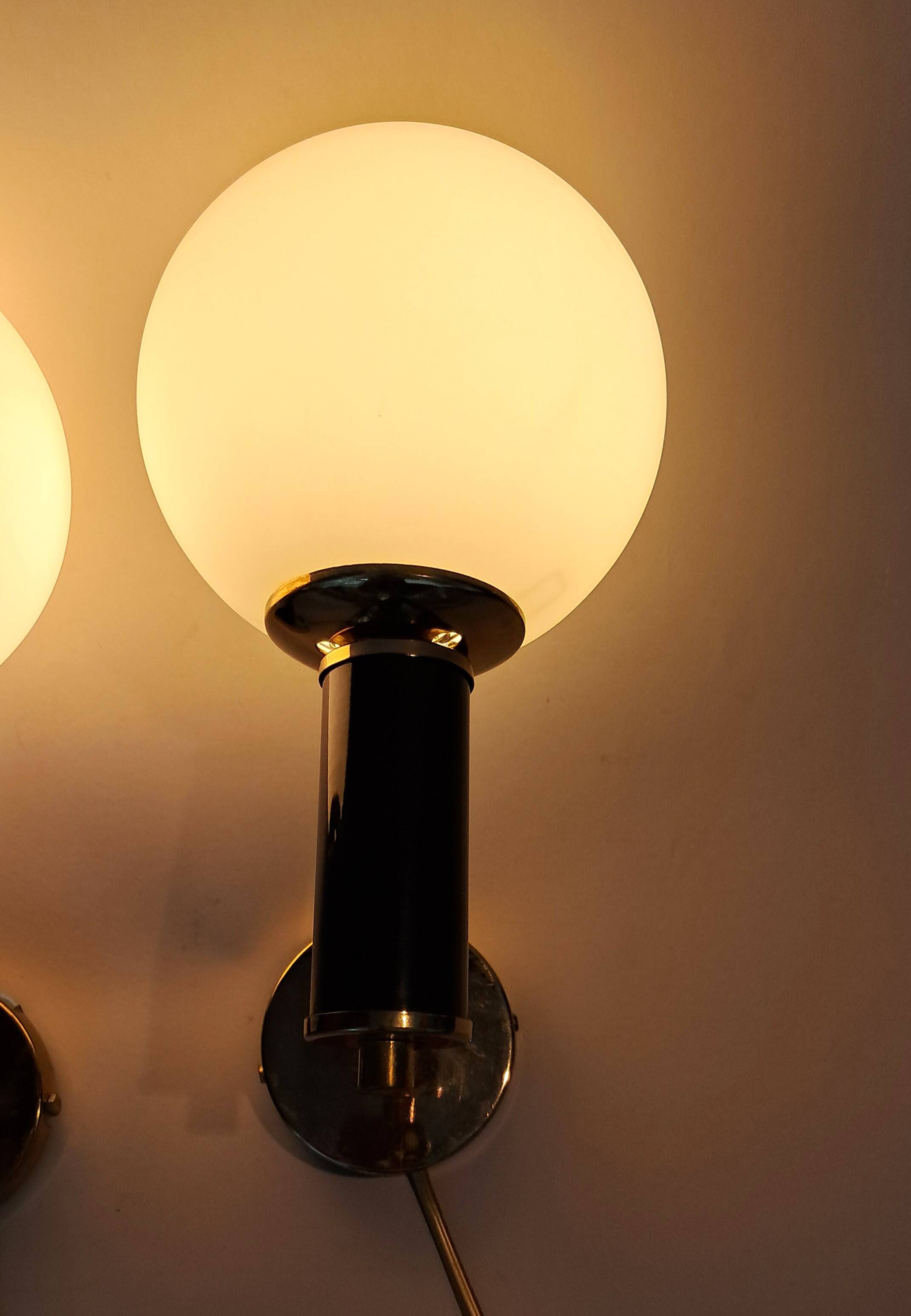 Pair of wall lights in gilded and black lacquered brass, Italy 1970/1980.