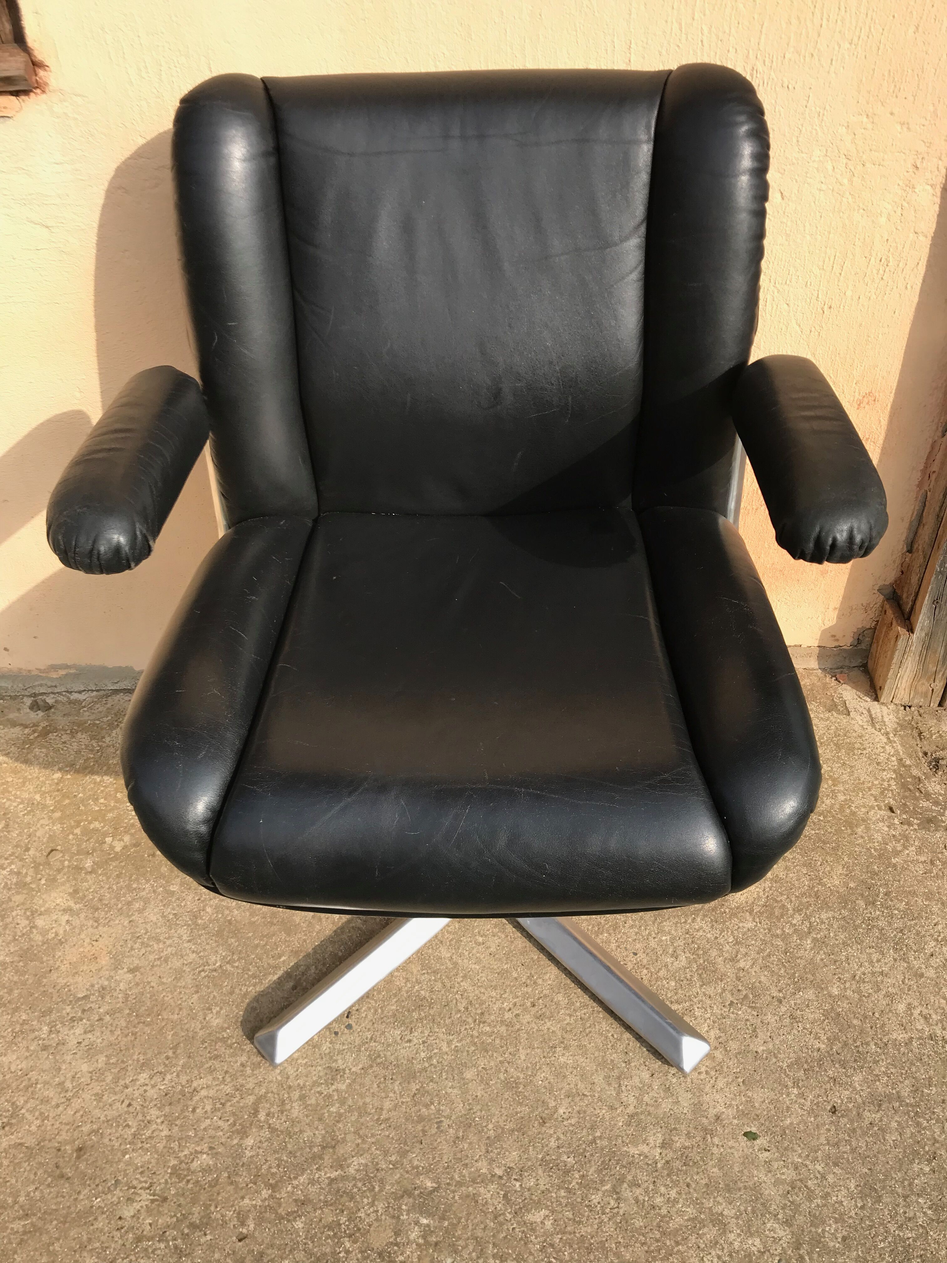 Vintage swivel black leather armchair