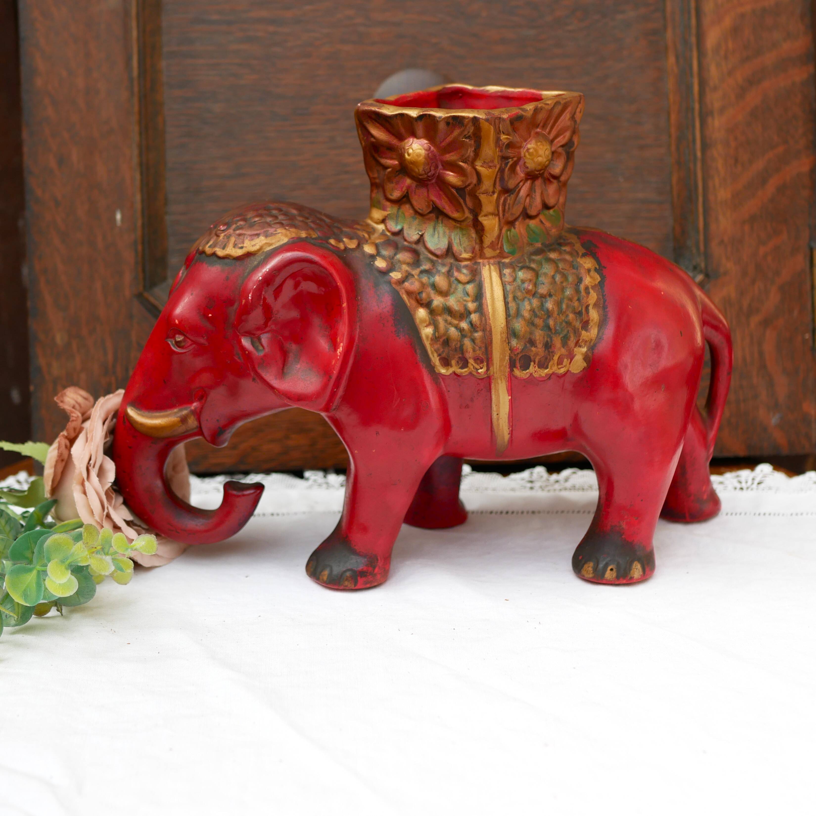 A pair of red and gold ceramic vases in the shape of elephants, 1940s.