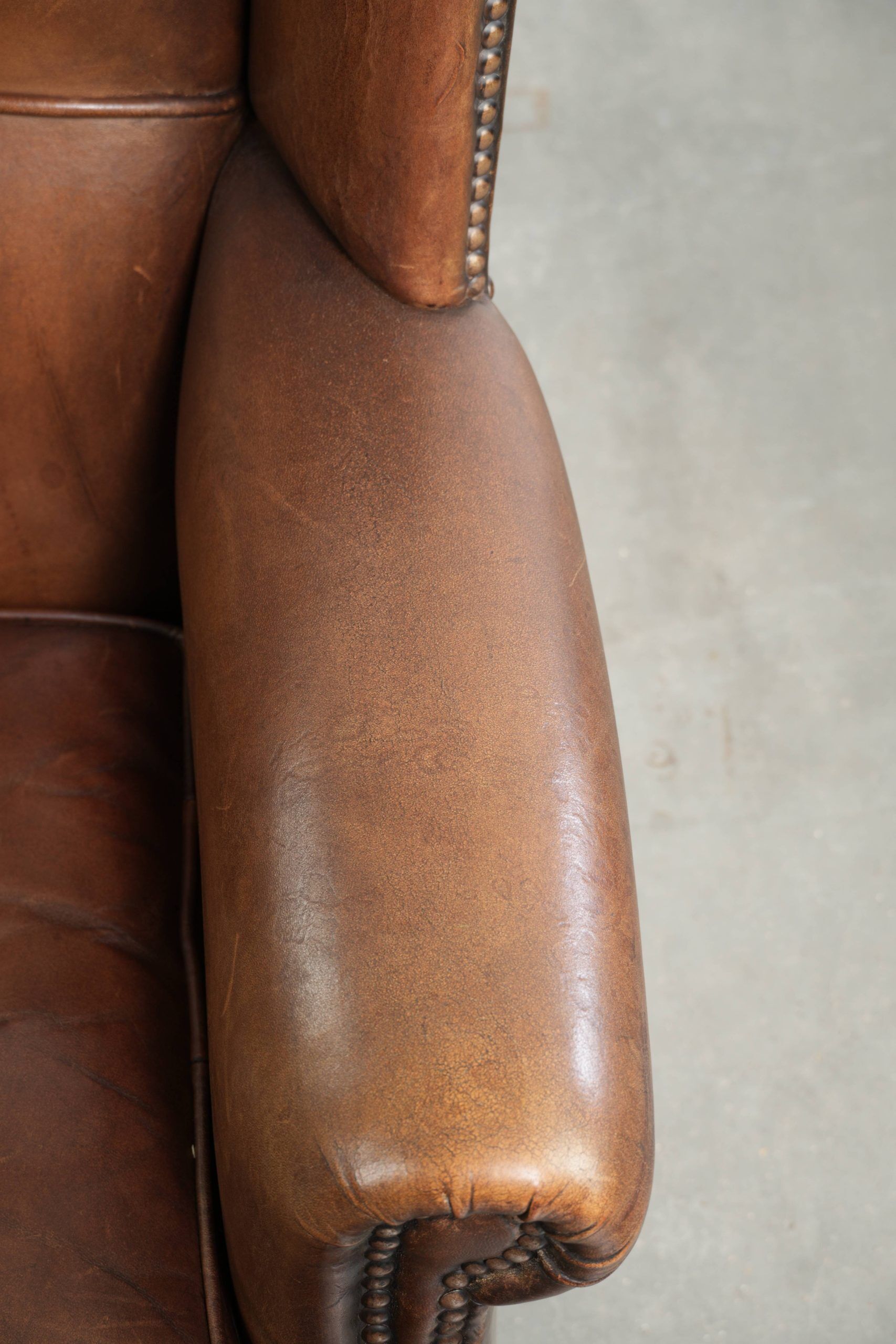 Subtle dark brown sheepskin wingback armchair with a timeless look subtle