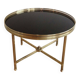 Round coffee table in brass with a black lacquered glass top by Maison Jansen.