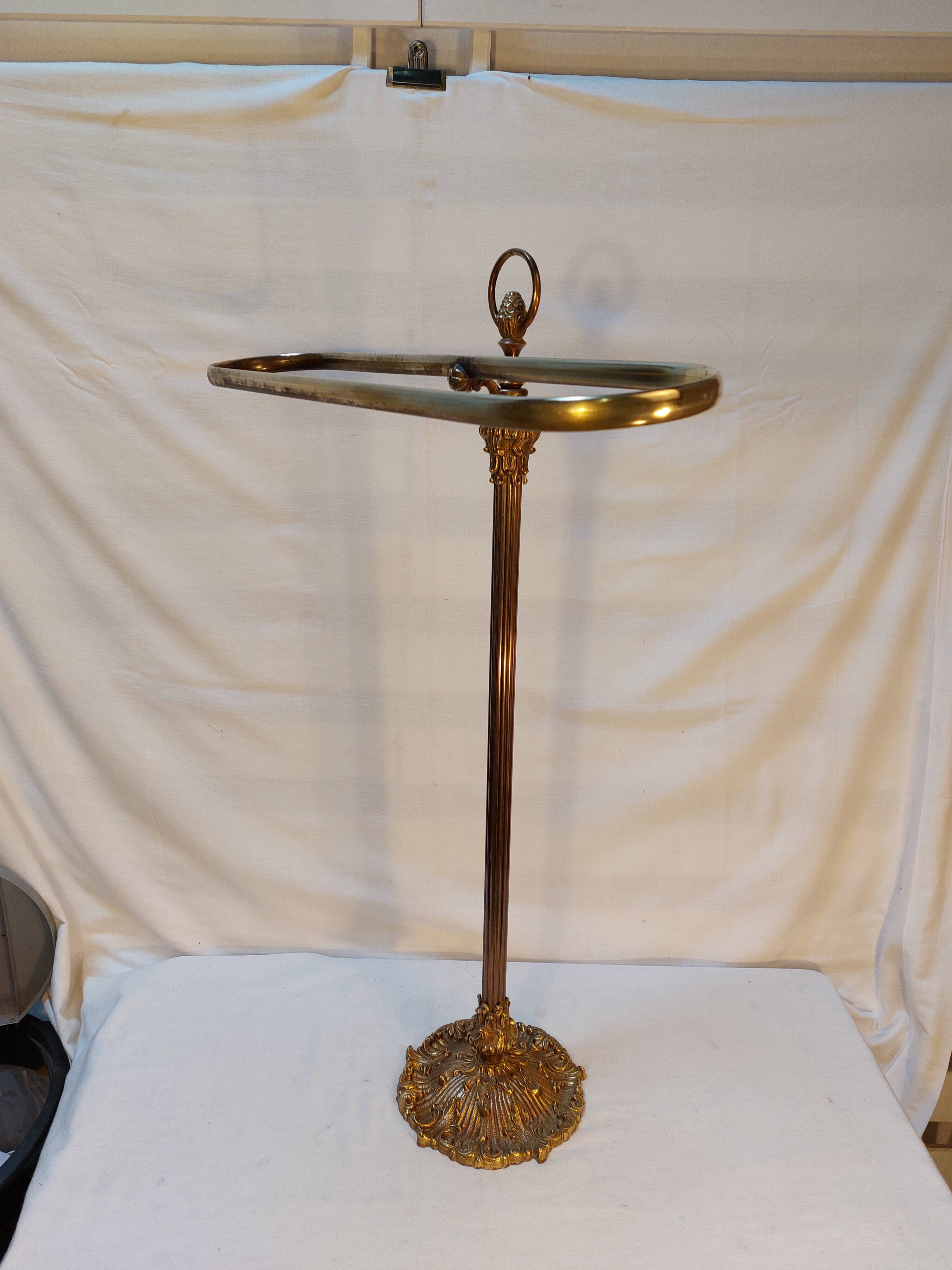 Old golden brass towel rack on baroque style foot