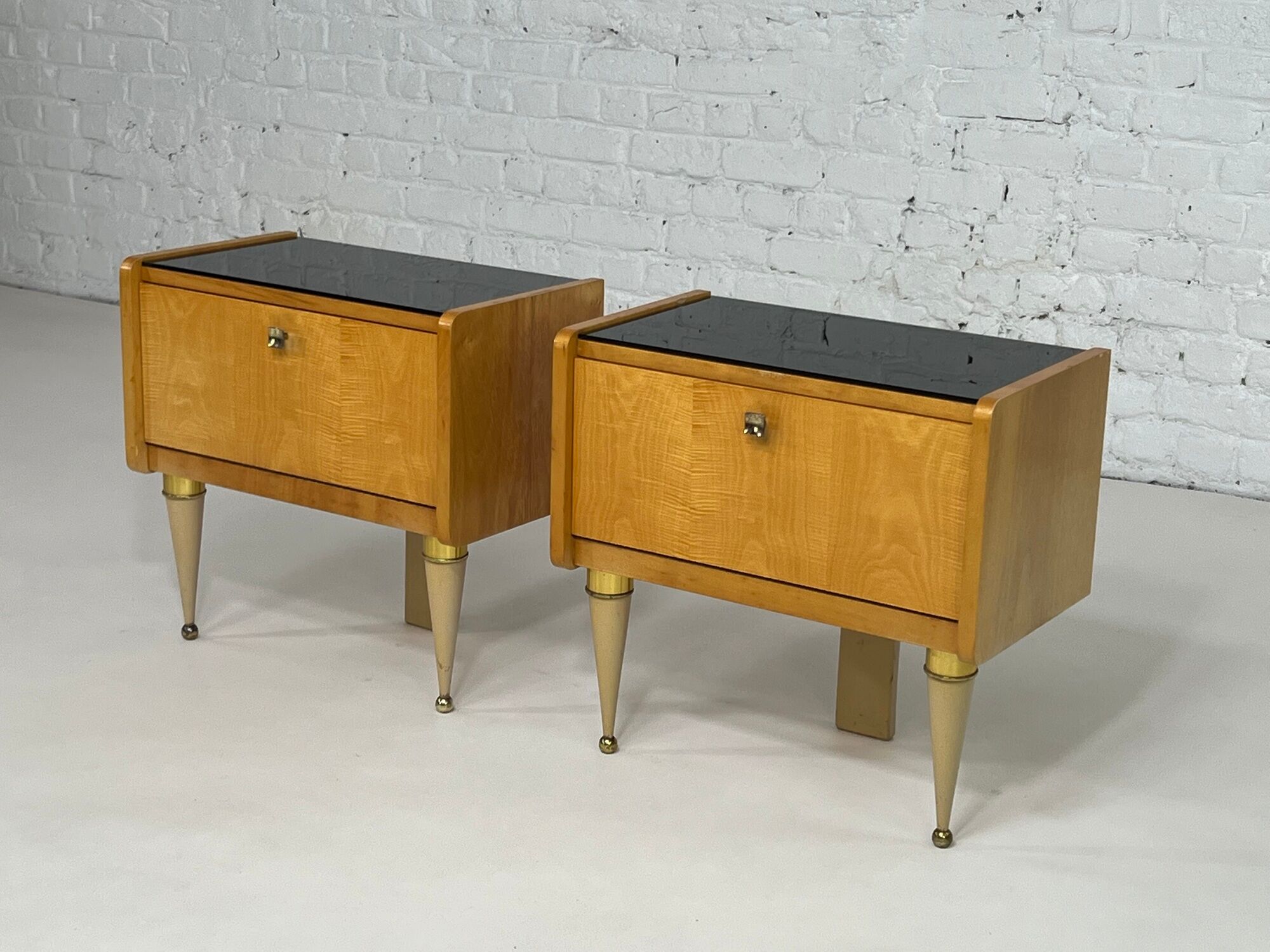 Pair of bedside tables in wood, brass and black glass top