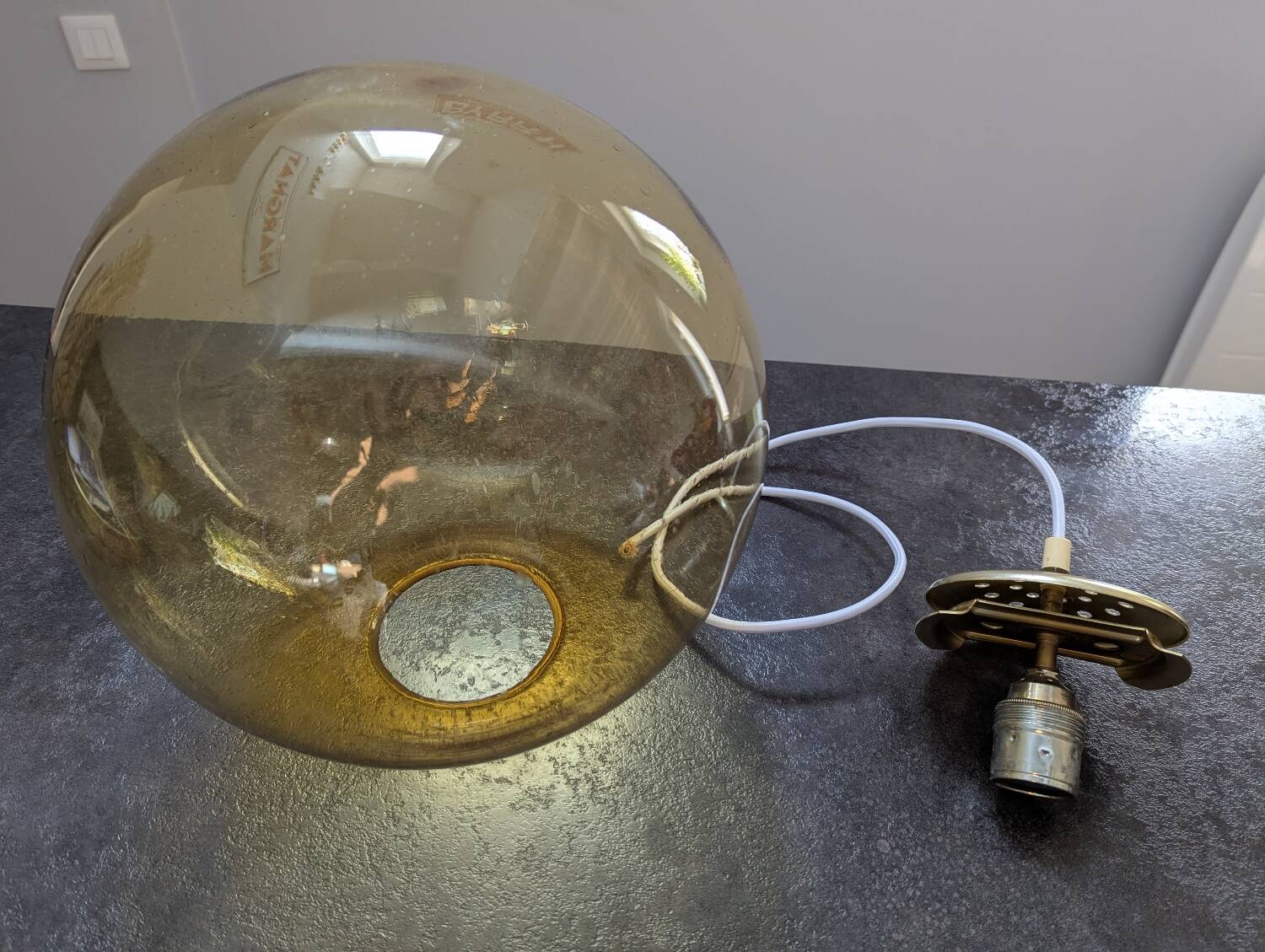 Old large and imposing thick glass globe with a bubbled amber colour, vintage.