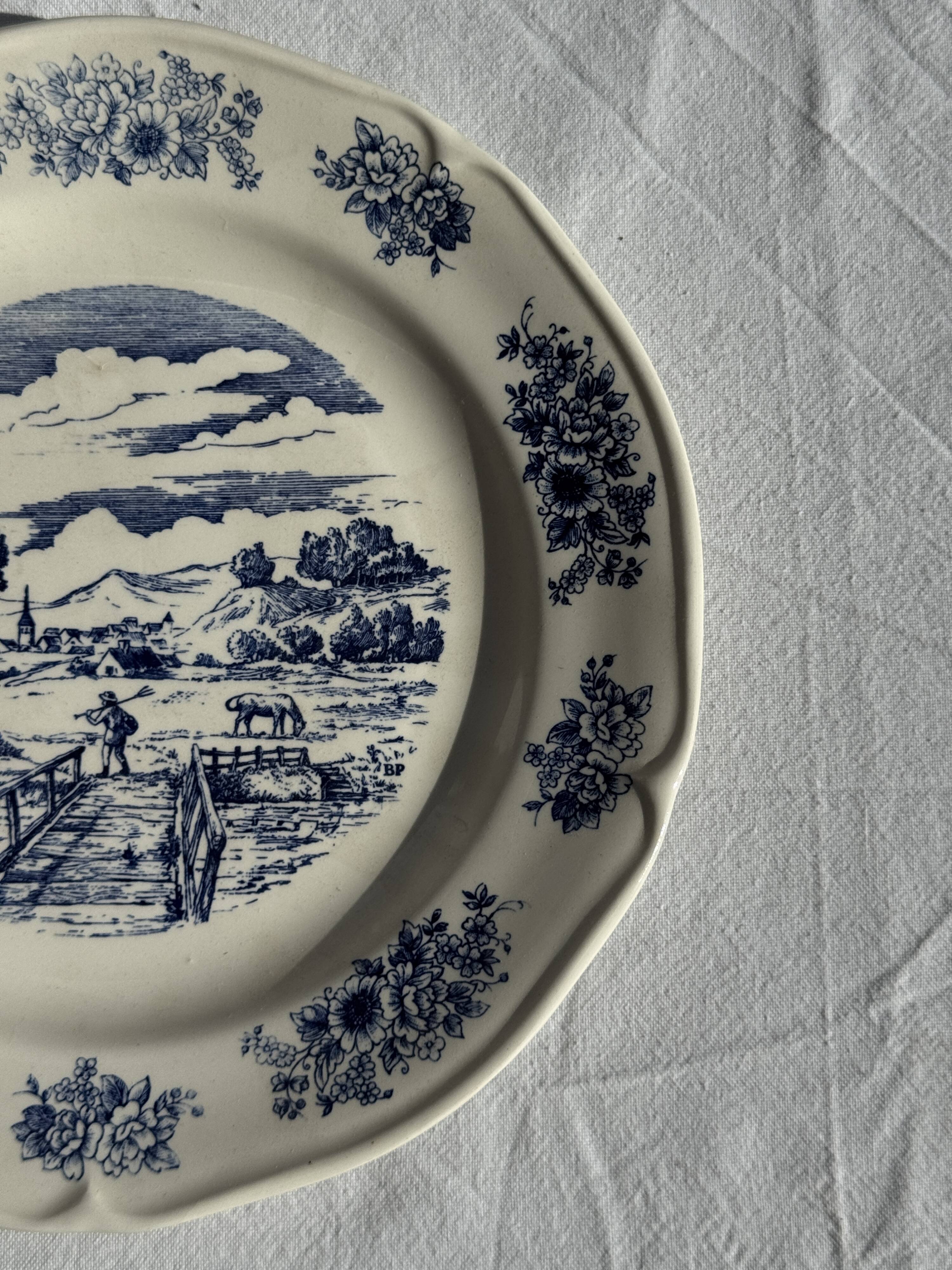 Assiette ancienne en faïence à décor de paysage bleu D24,5