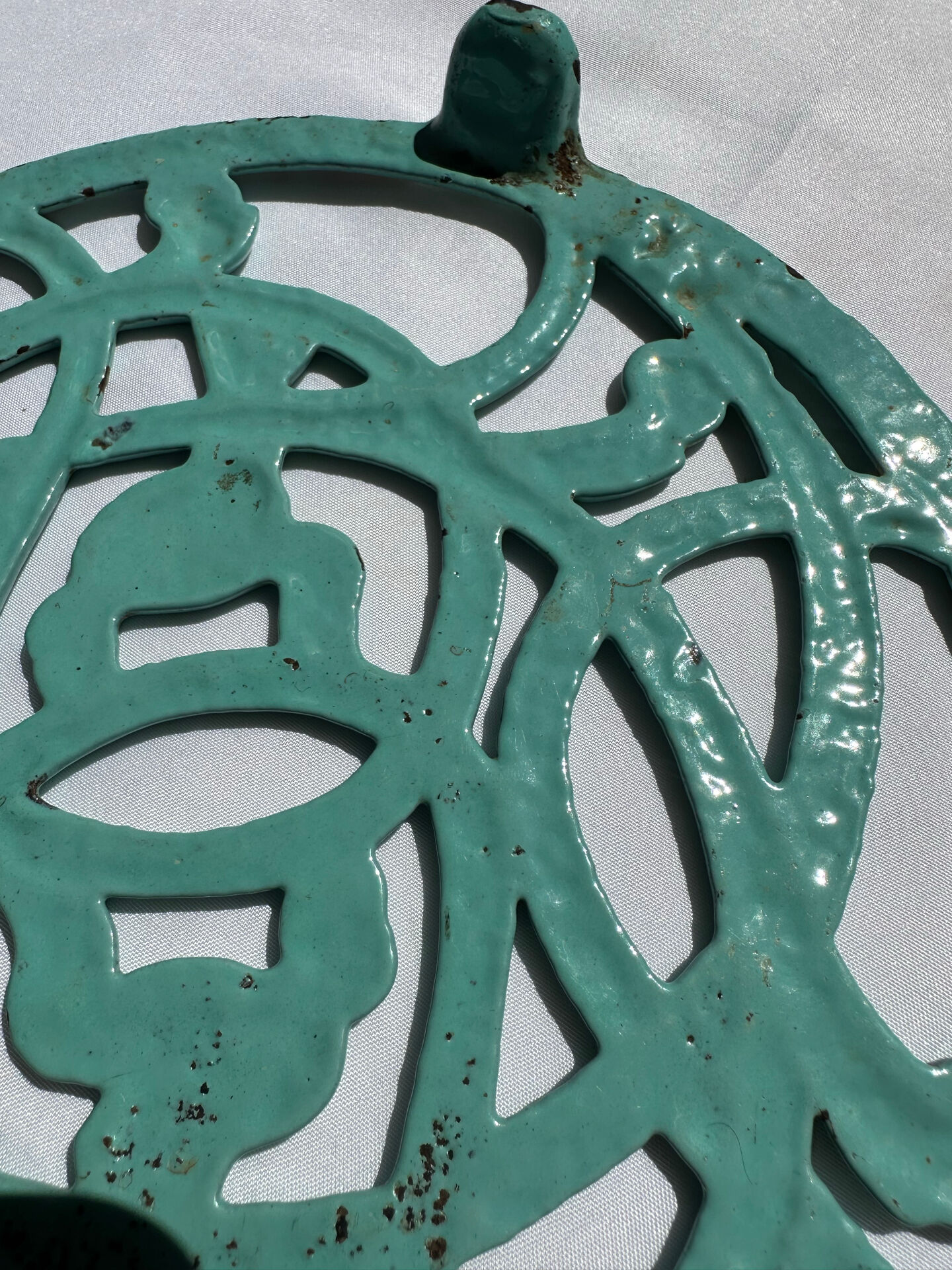 Enamelled cast iron trivet in blue with wrought iron decoration.
