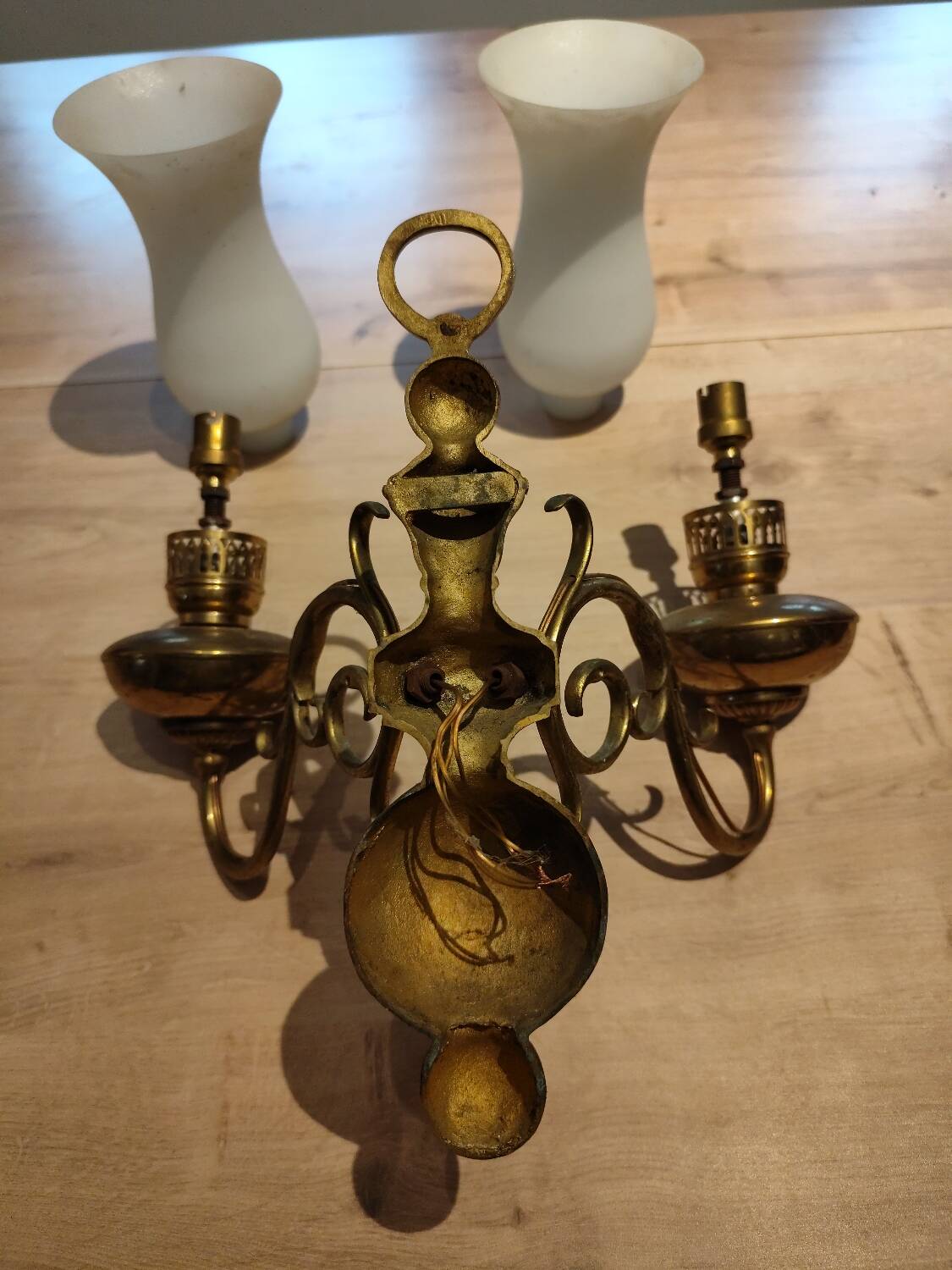 Antique brass wall sconce with two arms and glass shades