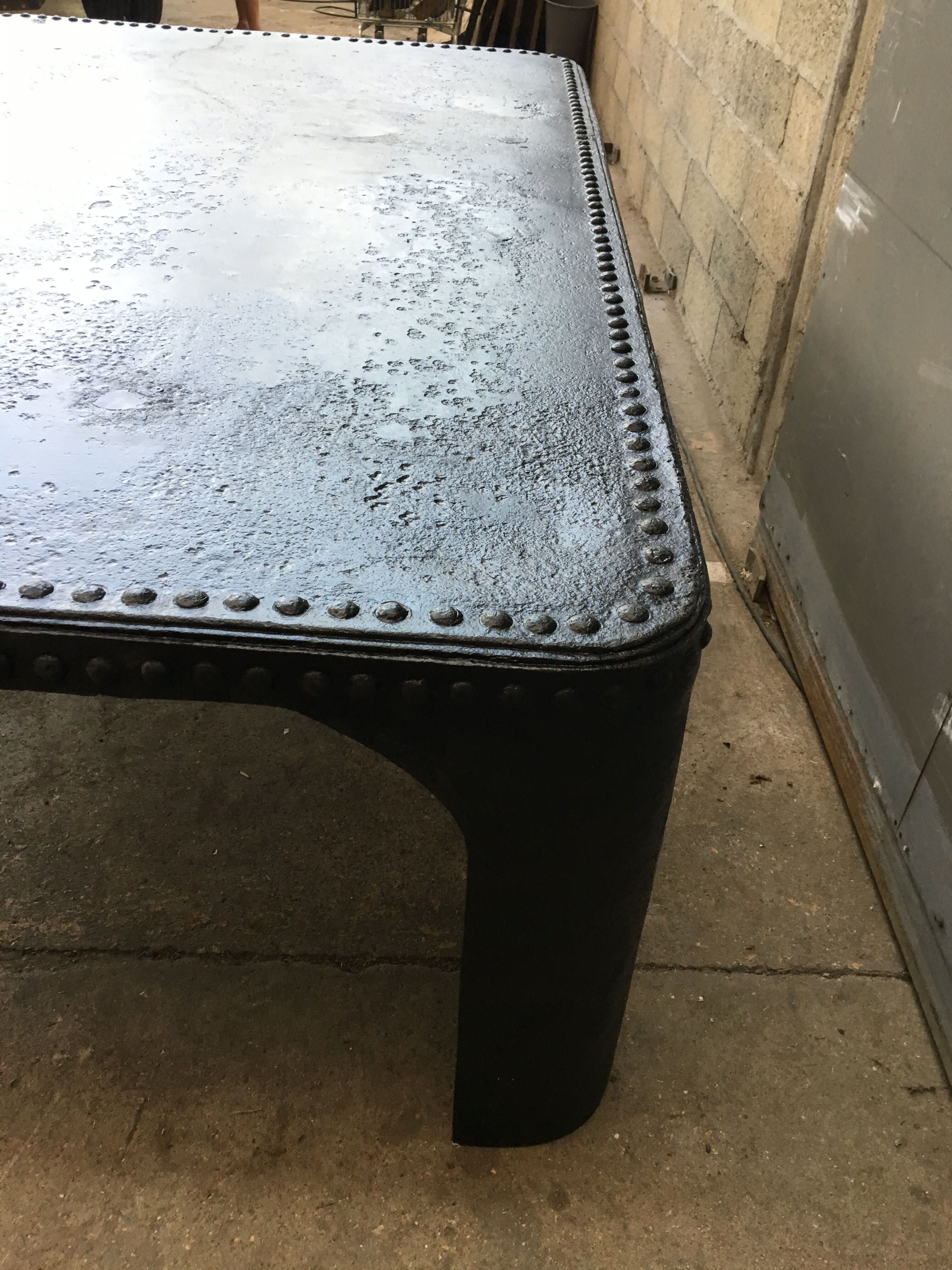 large industrial table in graphite black riveted metal