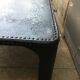 large industrial table in graphite black riveted metal