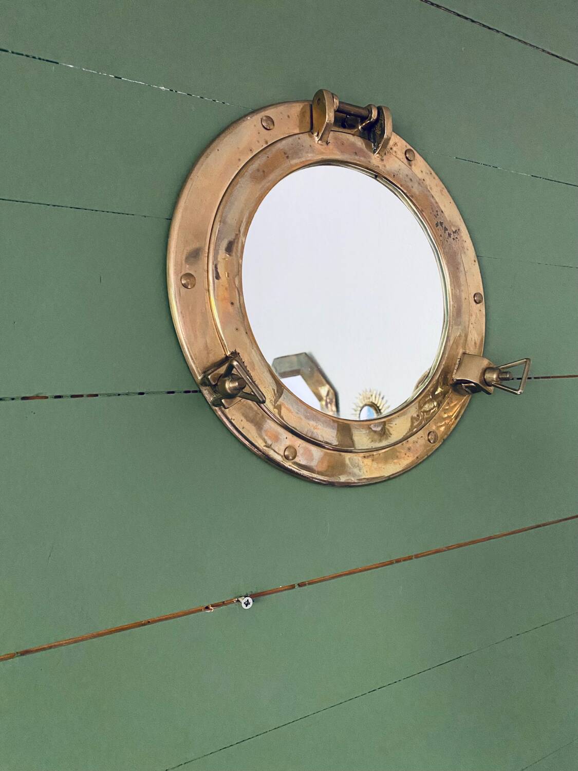 Porthole mirror in gilded brass