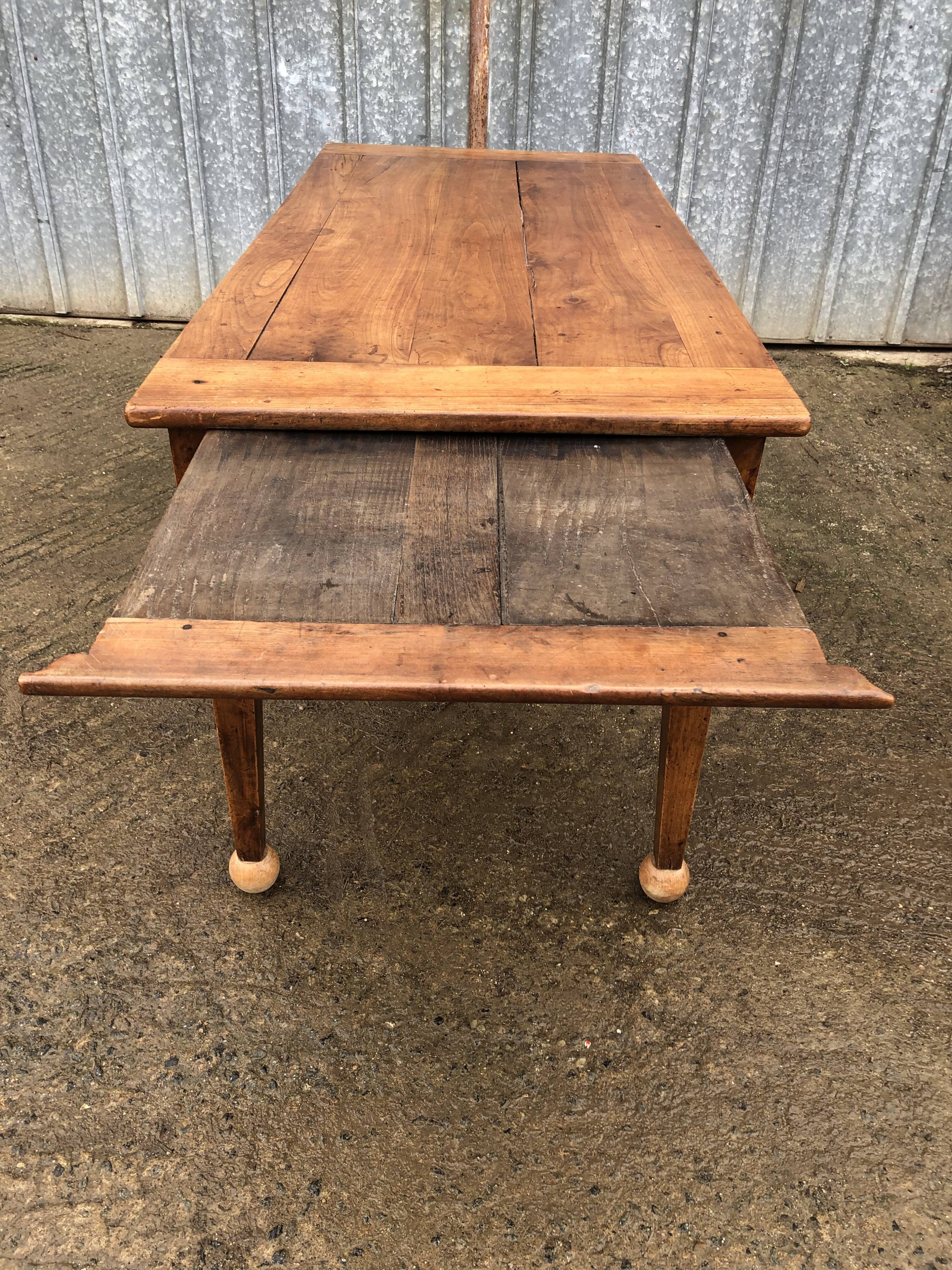 Antique solid cherry farmhouse table with 2 end drawers and 1 pull-out.