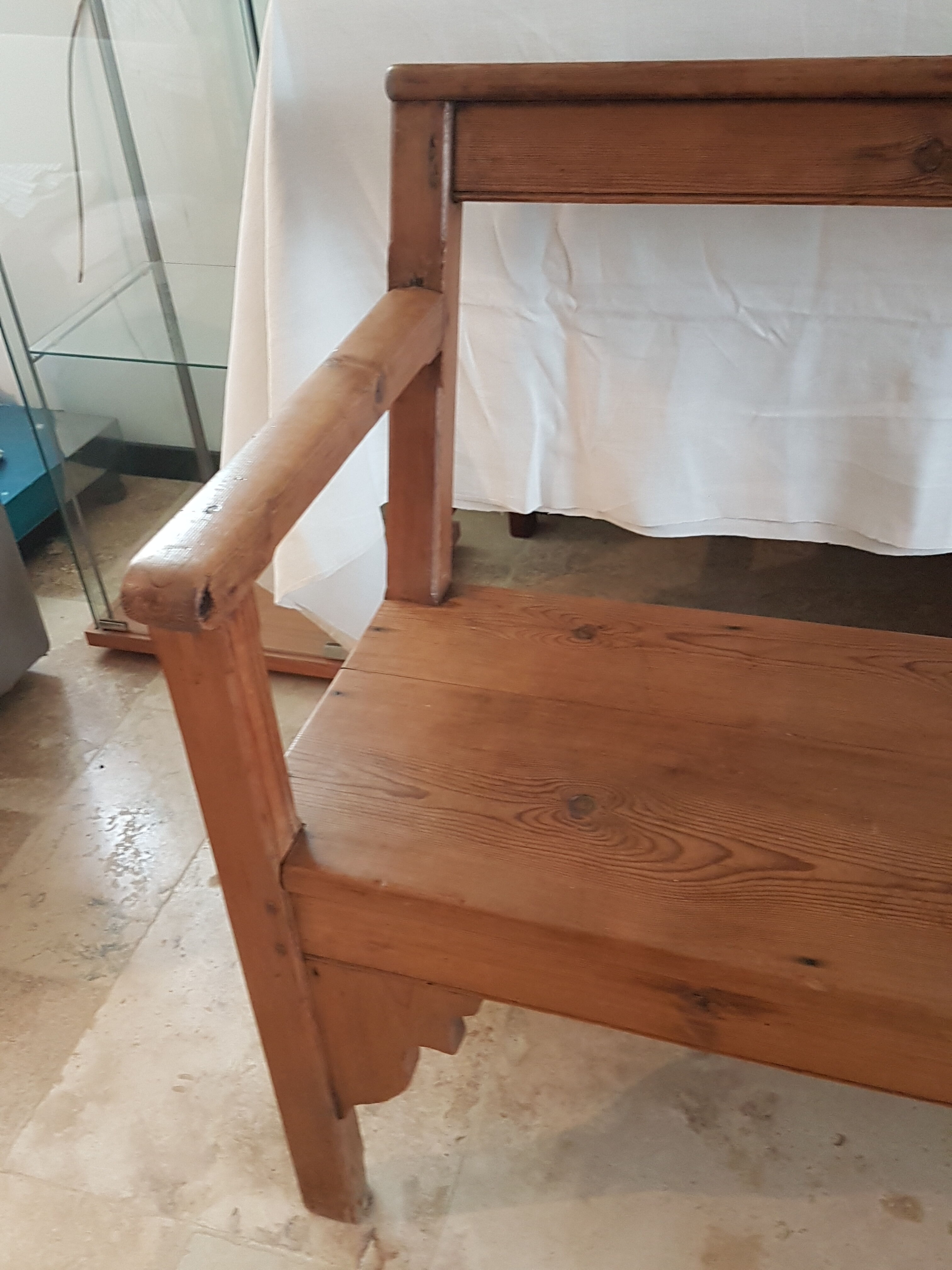 Church bench in fir tree with armrests