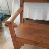 Church bench in fir tree with armrests