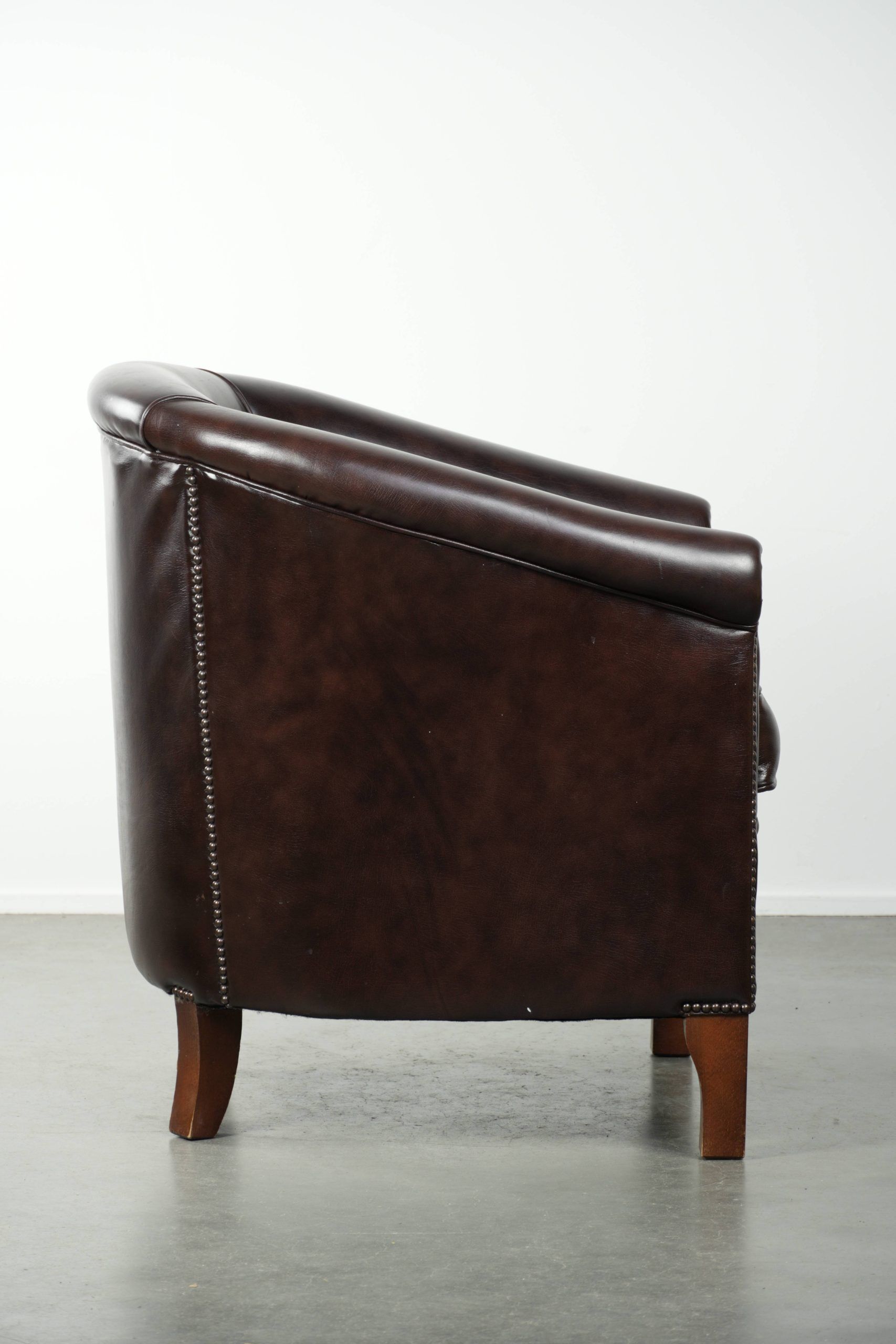 Dark cow leather club armchair in good condition with an English design