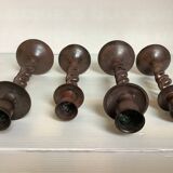 Four twisted metal candle holders with a rusty appearance