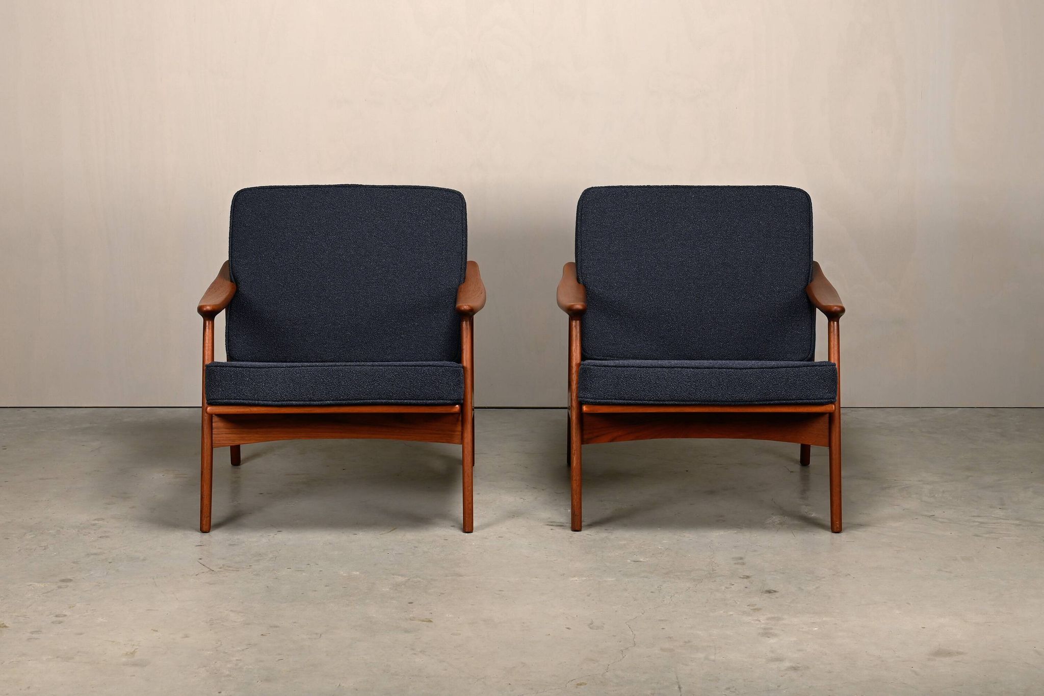 Pair Scandinavian Modern armchairs in teak and dark blue bouclé fabric
