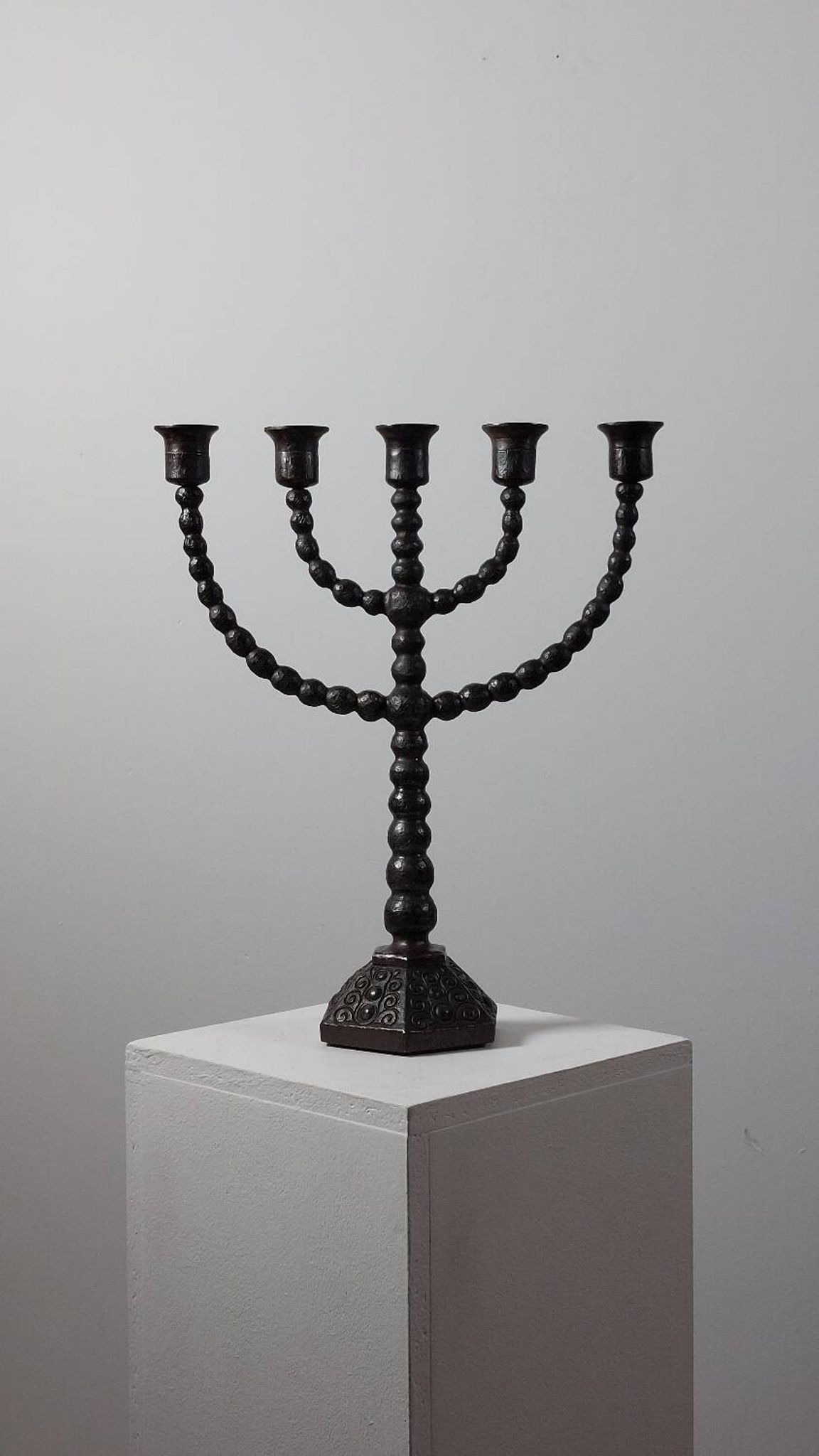 Candelabrum in the shape of a spool, skilfully forged in menorah style.