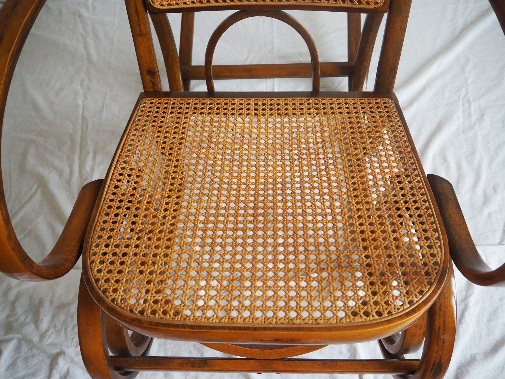 Rocking-chair en bois teinté et assise cannée
