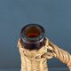 Bouteille en verre ambré dans son panier à poignée en osier