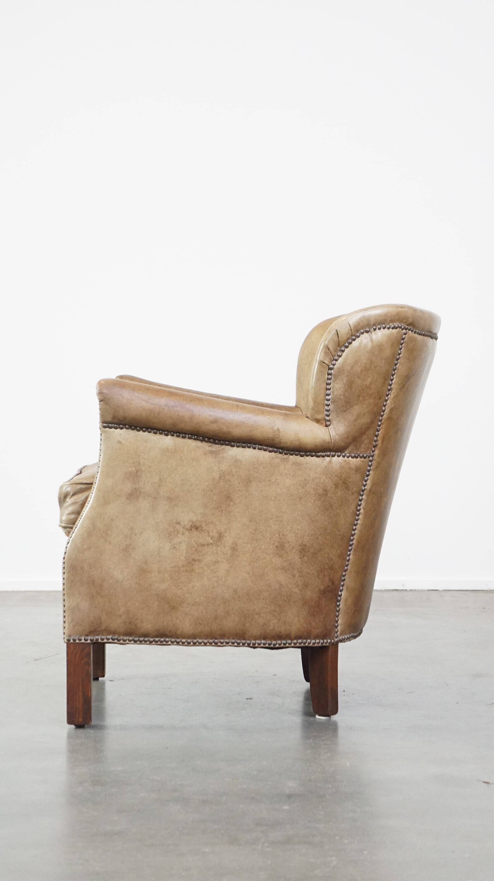 Subtle leather armchair with a reversible kilim seat cushion