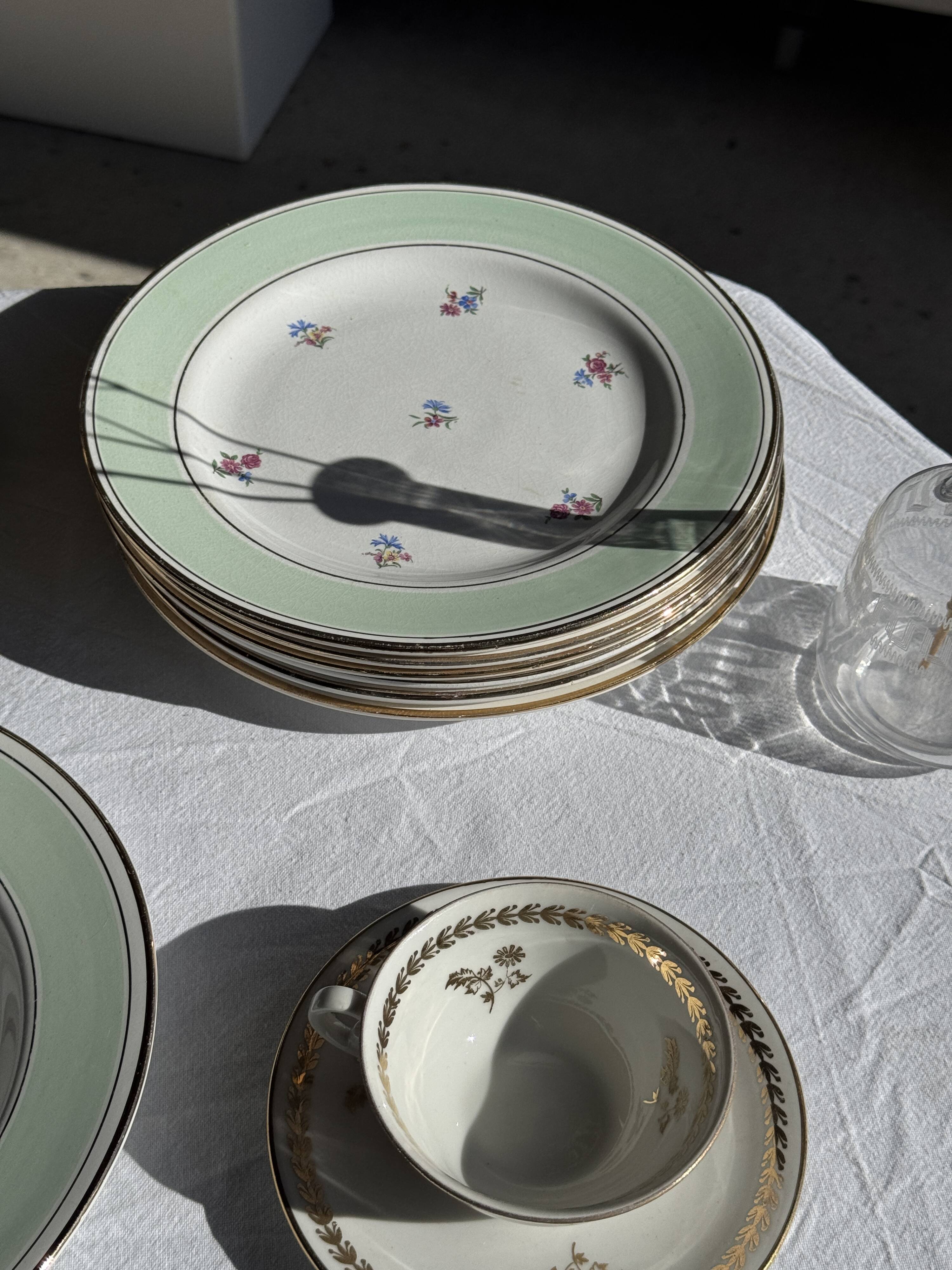 Set of 9 vintage turquoise deep plates with gold trim and pink flowers.