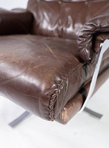 Easy chair upholstered with patinated brown leather and frame in metal, designed by Arne Norell