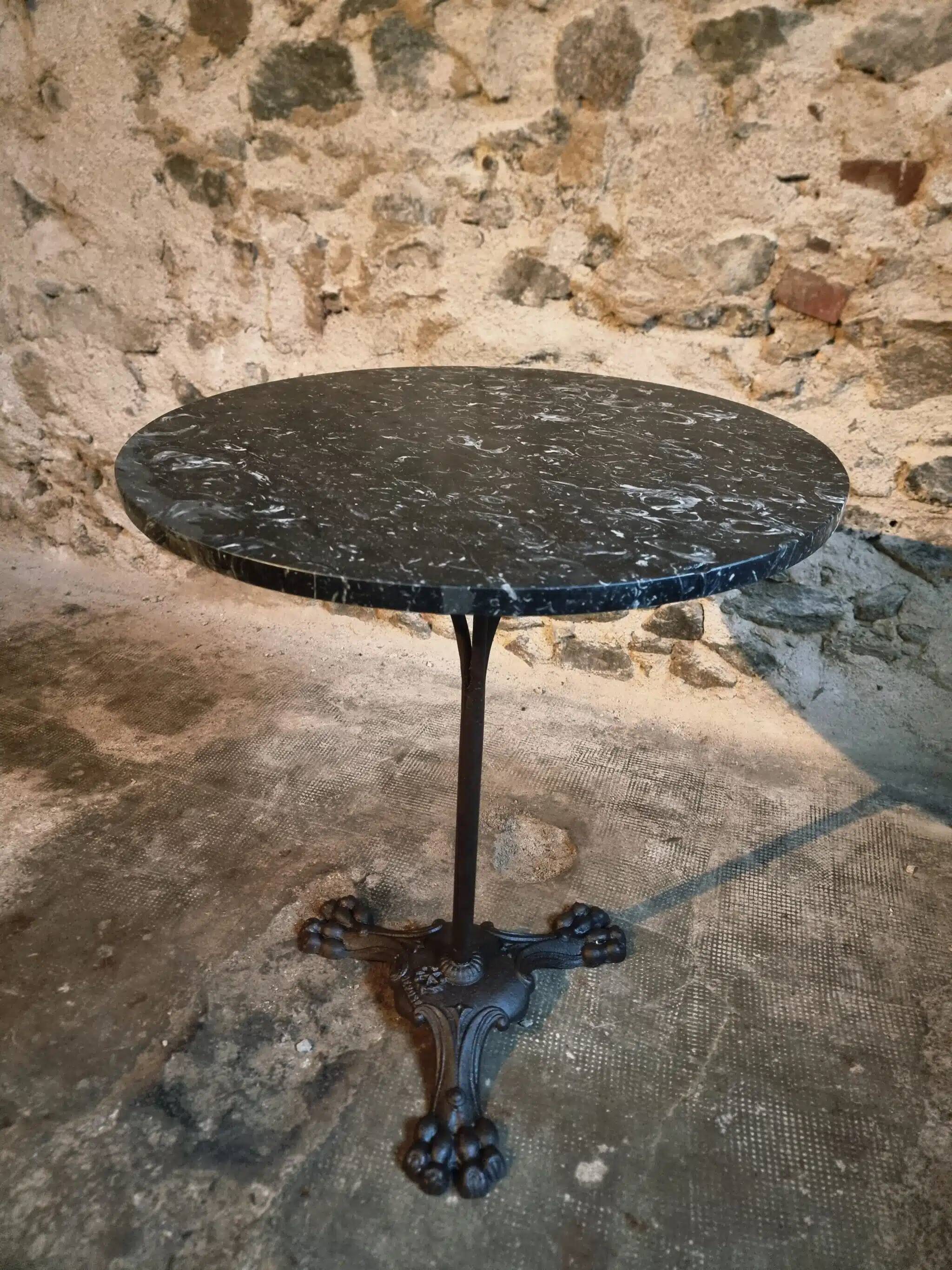 Old French bistro table with a marble top and a cast iron base.