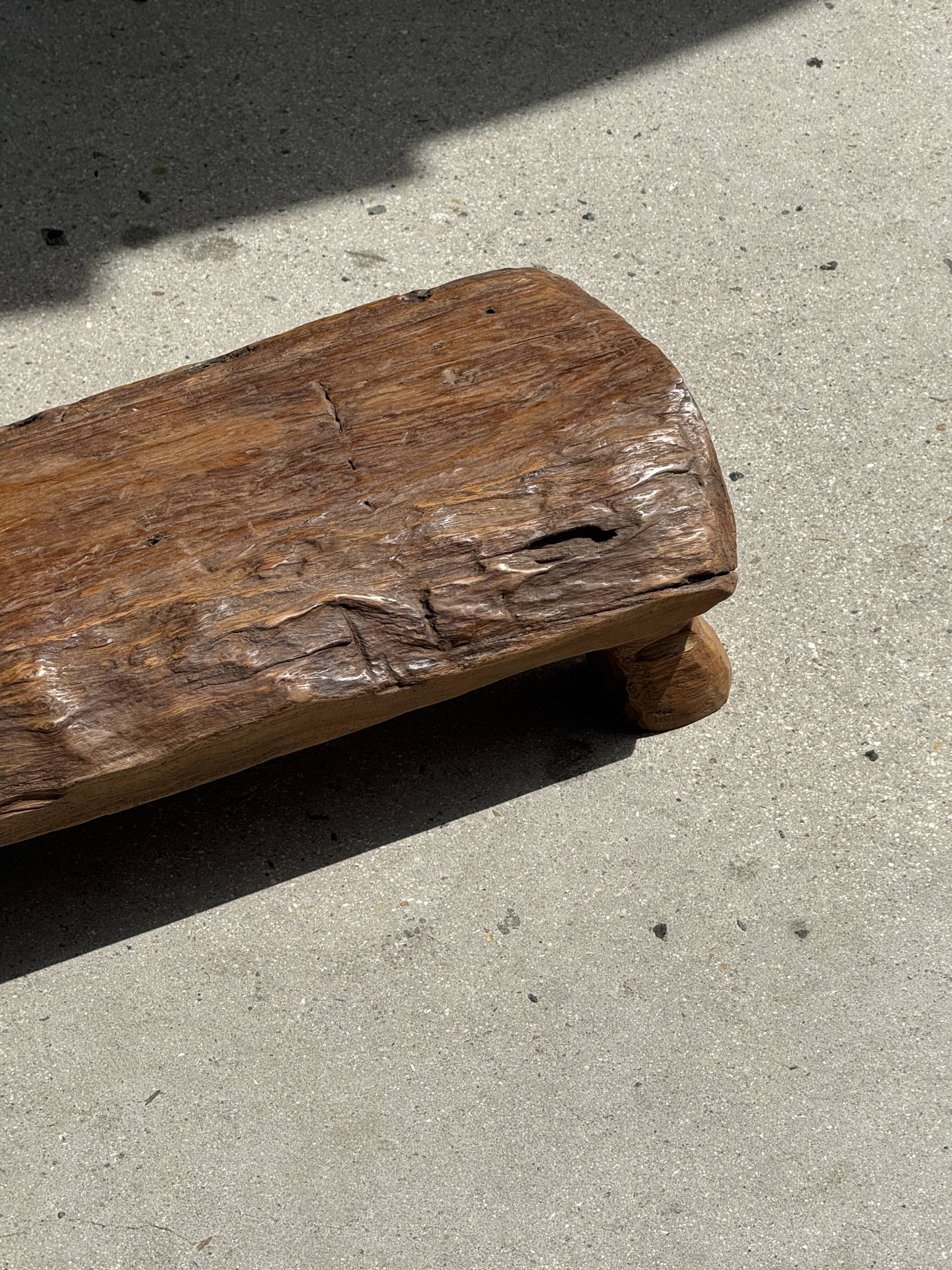 Small stool, footrest in blond teak, organic monoxyle with cut corners.