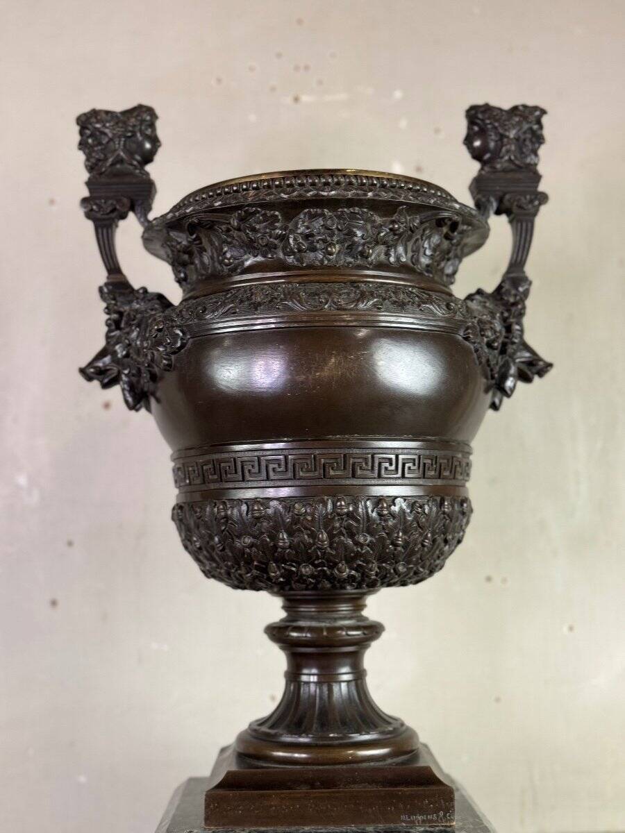 Patinated bronze vase with handles topped by bicéphalic busts, 19th century.
