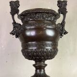 Patinated bronze vase with handles topped by bicéphalic busts, 19th century.
