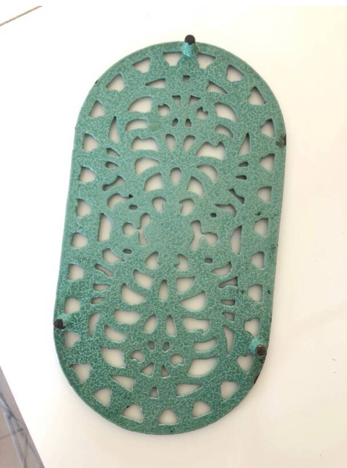 Old oval trivet in green enameled cast iron