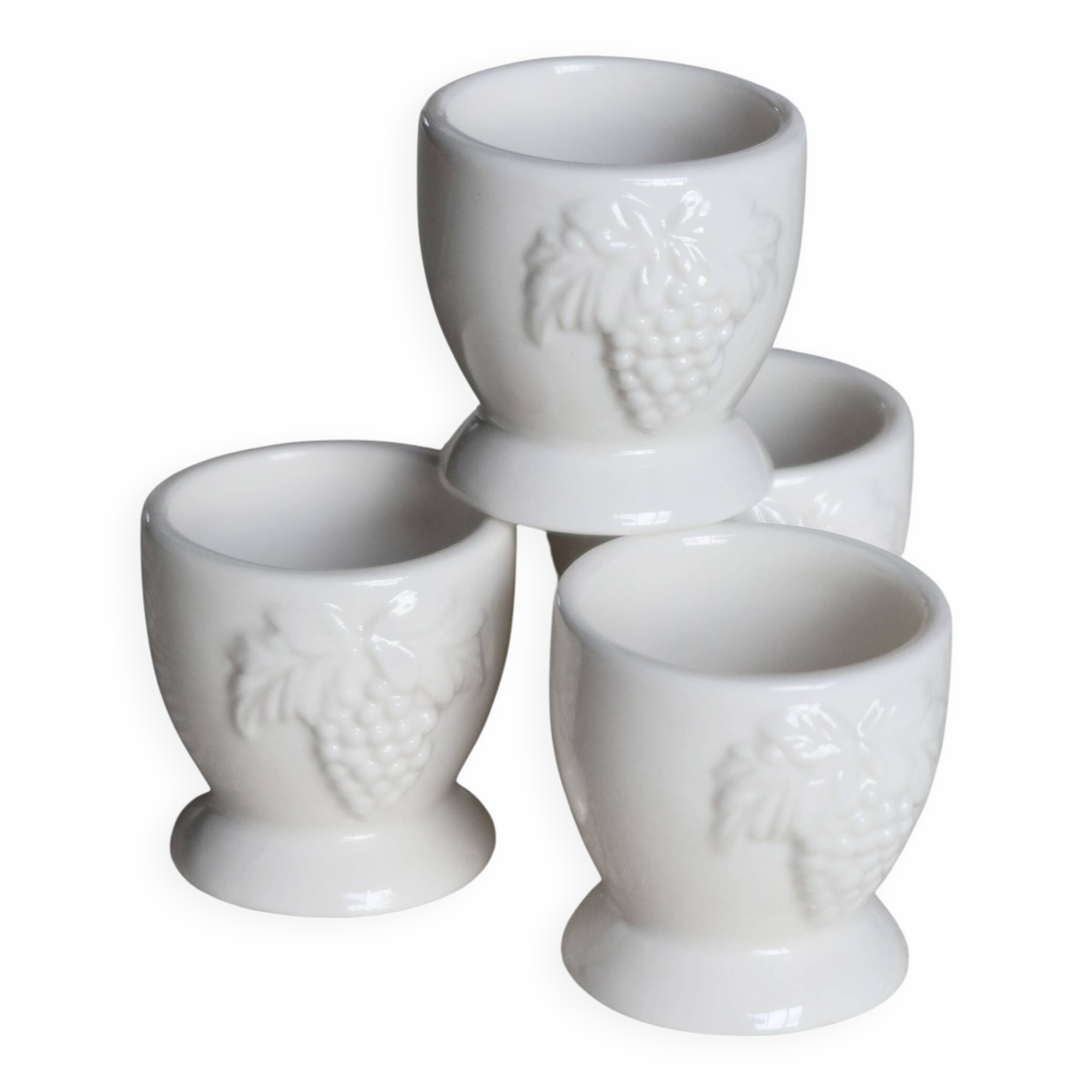Vintage white porcelain egg cups with fruit motif.