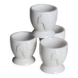 Vintage white porcelain egg cups with fruit motif.