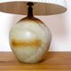 Large stone lamp with a cotton shade.