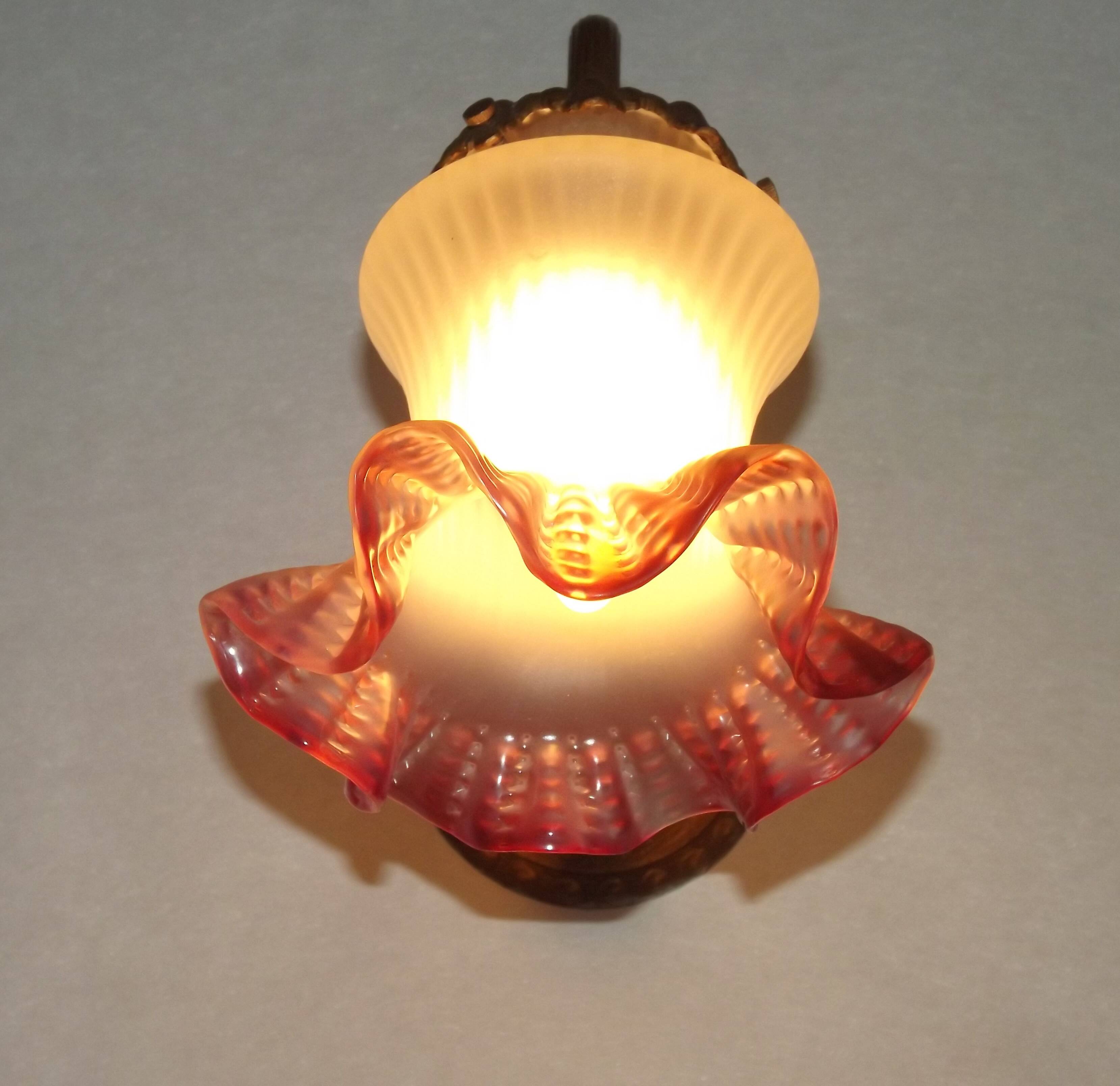 French Art Nouveau wall sconce in bronze with a white and pink glass shade.