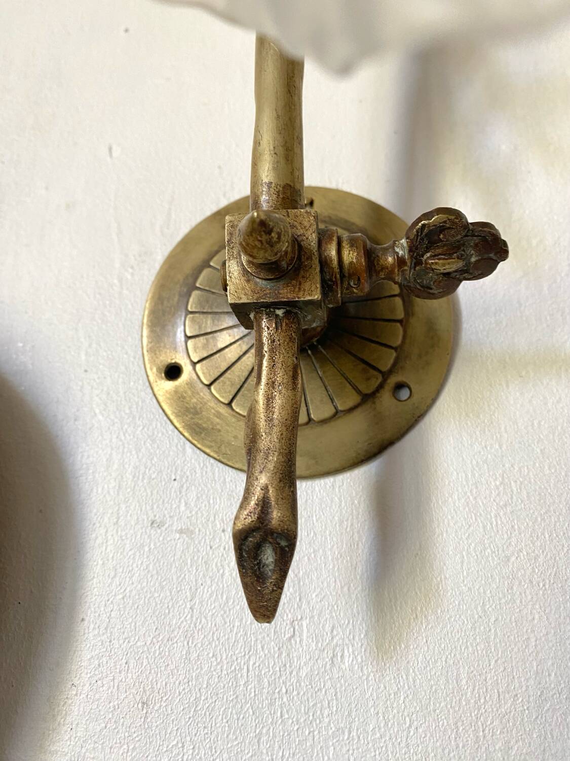 Antique brass wall light with glass shade.