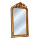 Grand miroir baroque en or avec un crête orné.