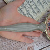 Antique hand mirror with stitched glass