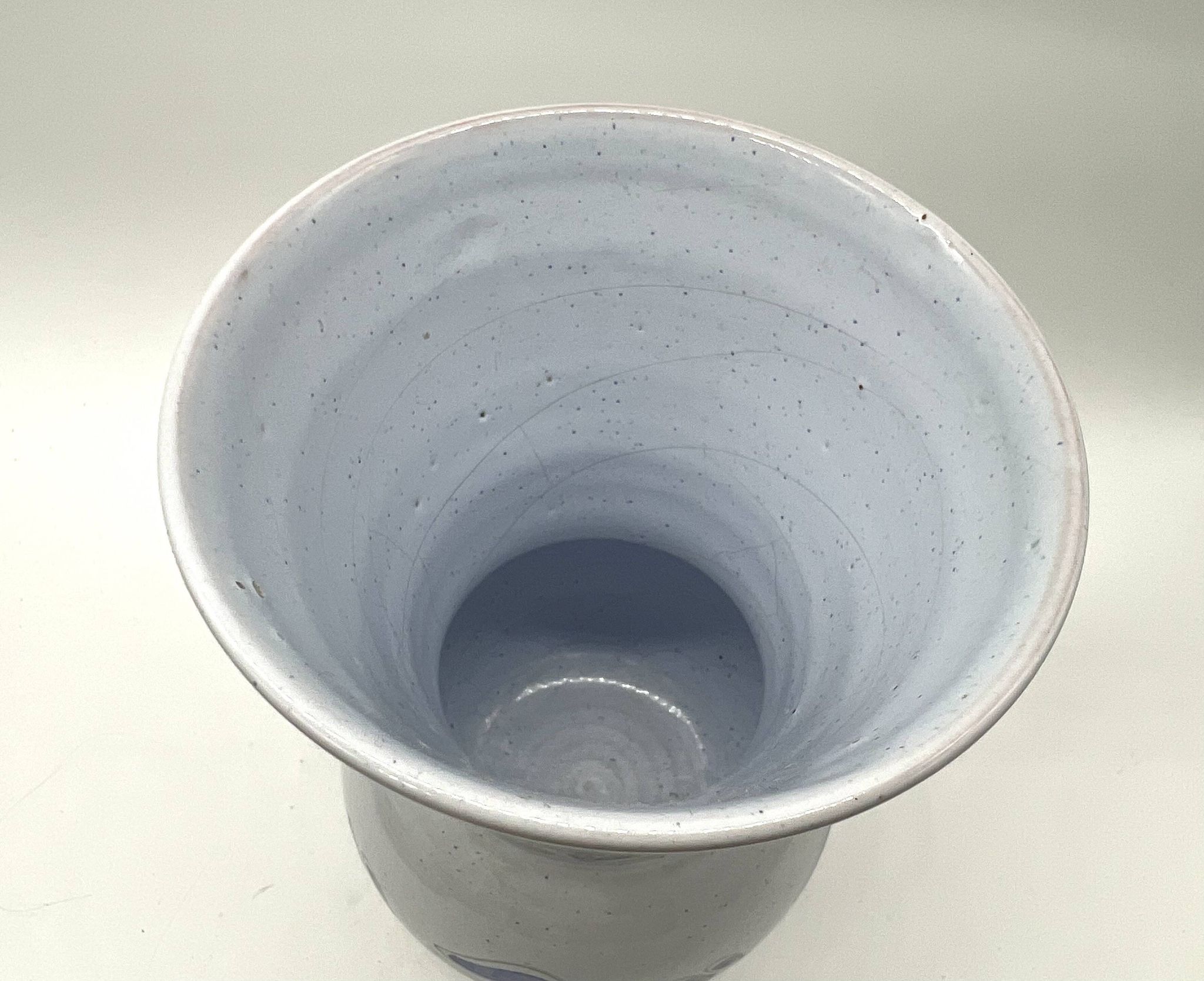 Vase en faïence émaillée bleue à décor floral stylisé, signé à la base