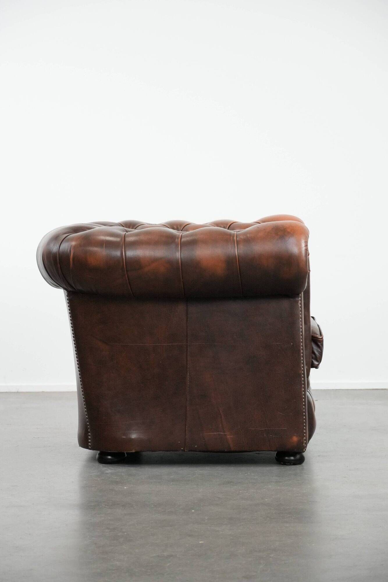 Brown Chesterfield armchair made of cowhide leather in English style