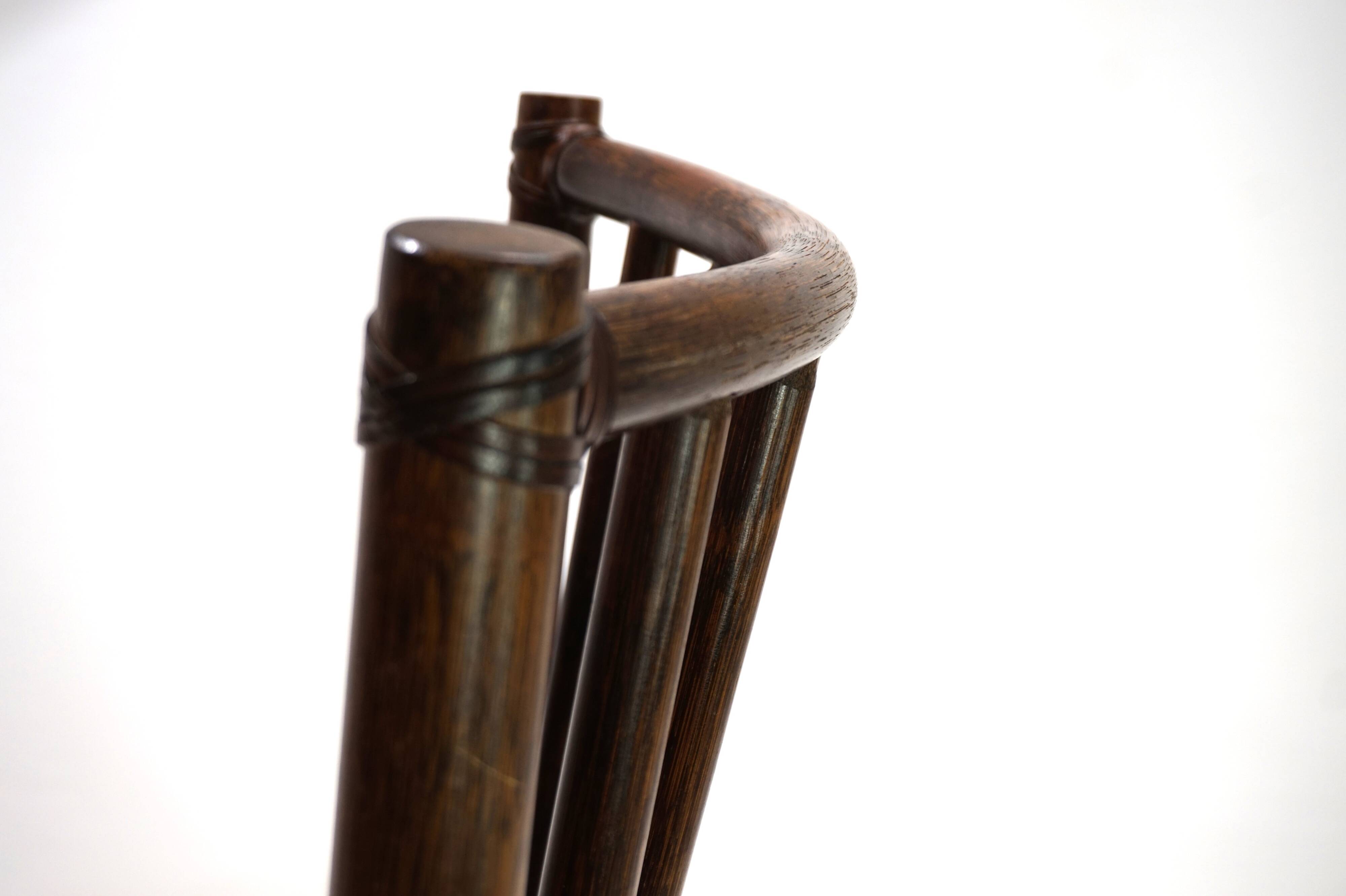 Fauteuil Manou en rotin et assise en cuir, 1960