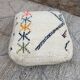 Berber floor pouf: Handwoven Moroccan wool cushion.