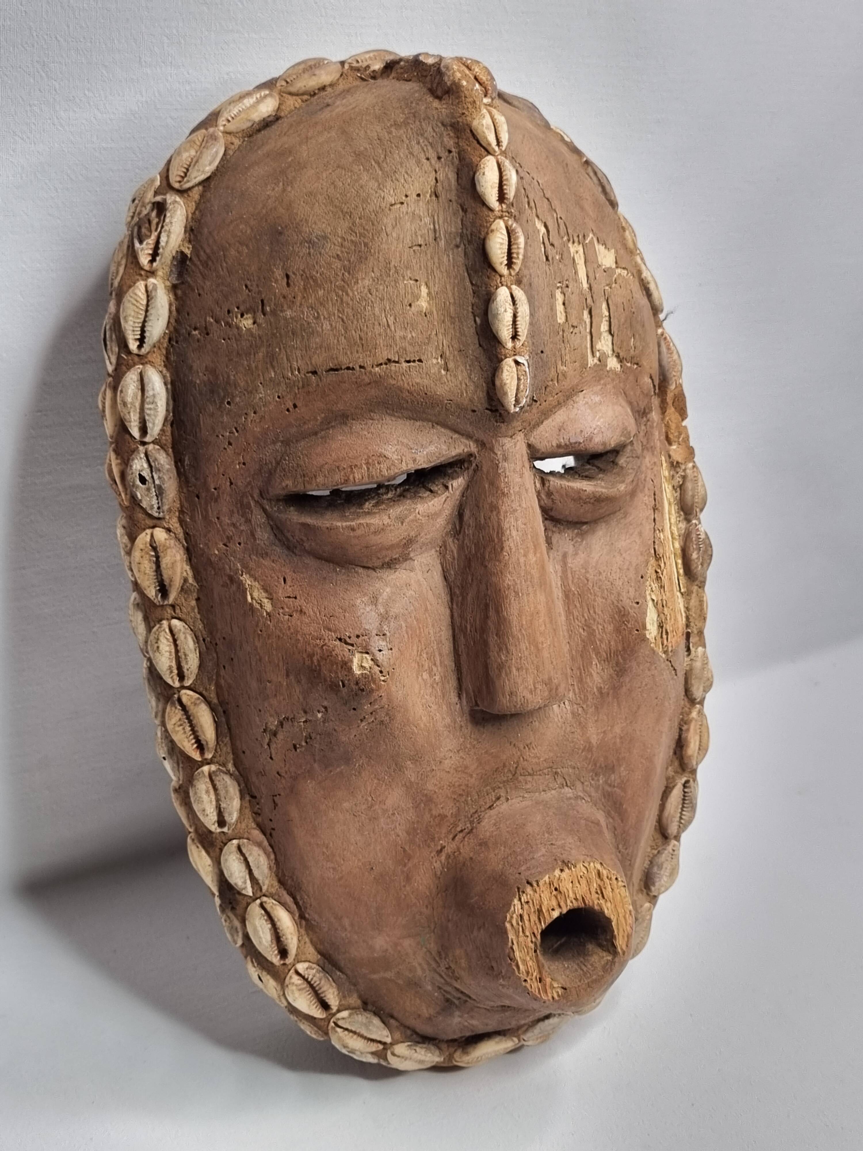 Decorative African mask in carved wood and cowrie shells, Baoulé style, 34 cm